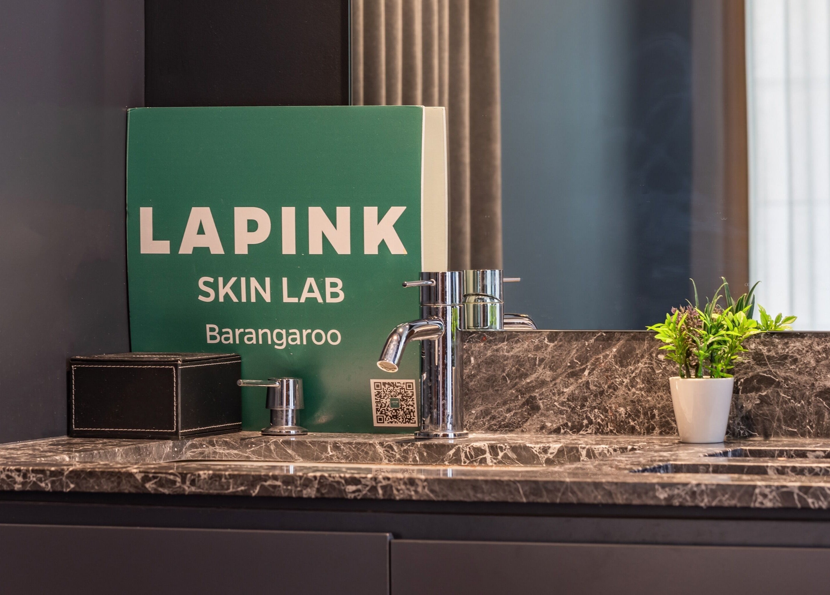 Elegant vanity at Lapink Skin Lab, Barangaroo, New South Wales, AU with plant and branded signage.