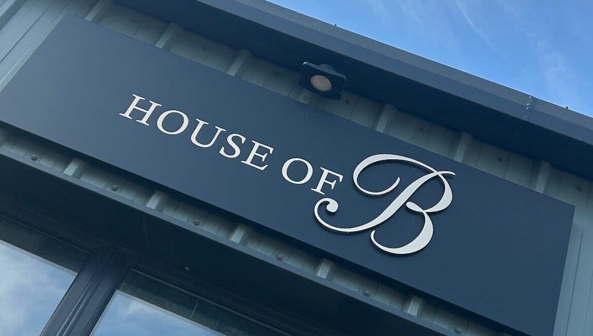 House of B front signage displaying the elegant logo in Caistor, England, GB under a clear blue sky.