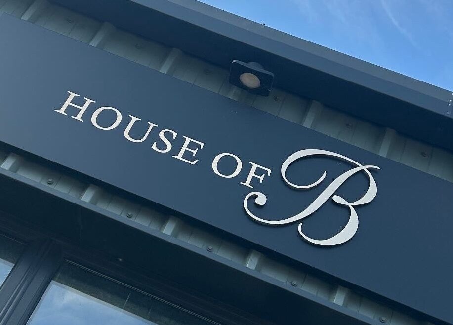 House of B front signage displaying the elegant logo in Caistor, England, GB under a clear blue sky.