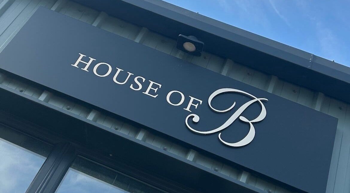 House of B front signage displaying the elegant logo in Caistor, England, GB under a clear blue sky.