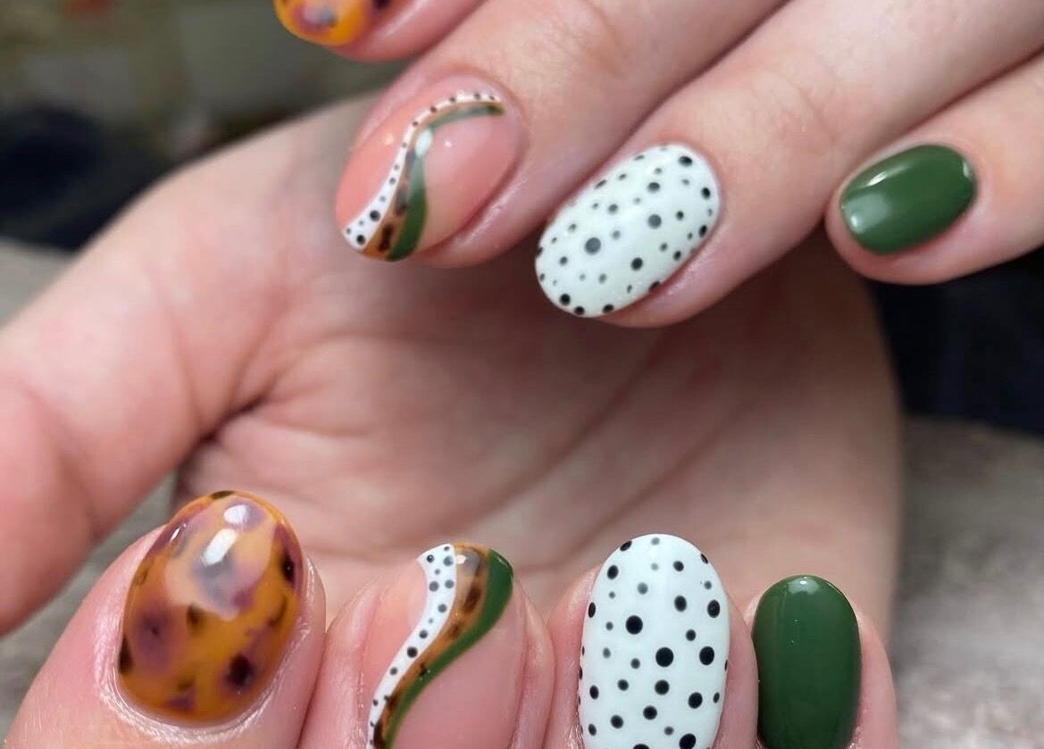 Close-up of trendy nail art at House of B, Caistor, England, GB. Unique design with green, white, and brown patterns.