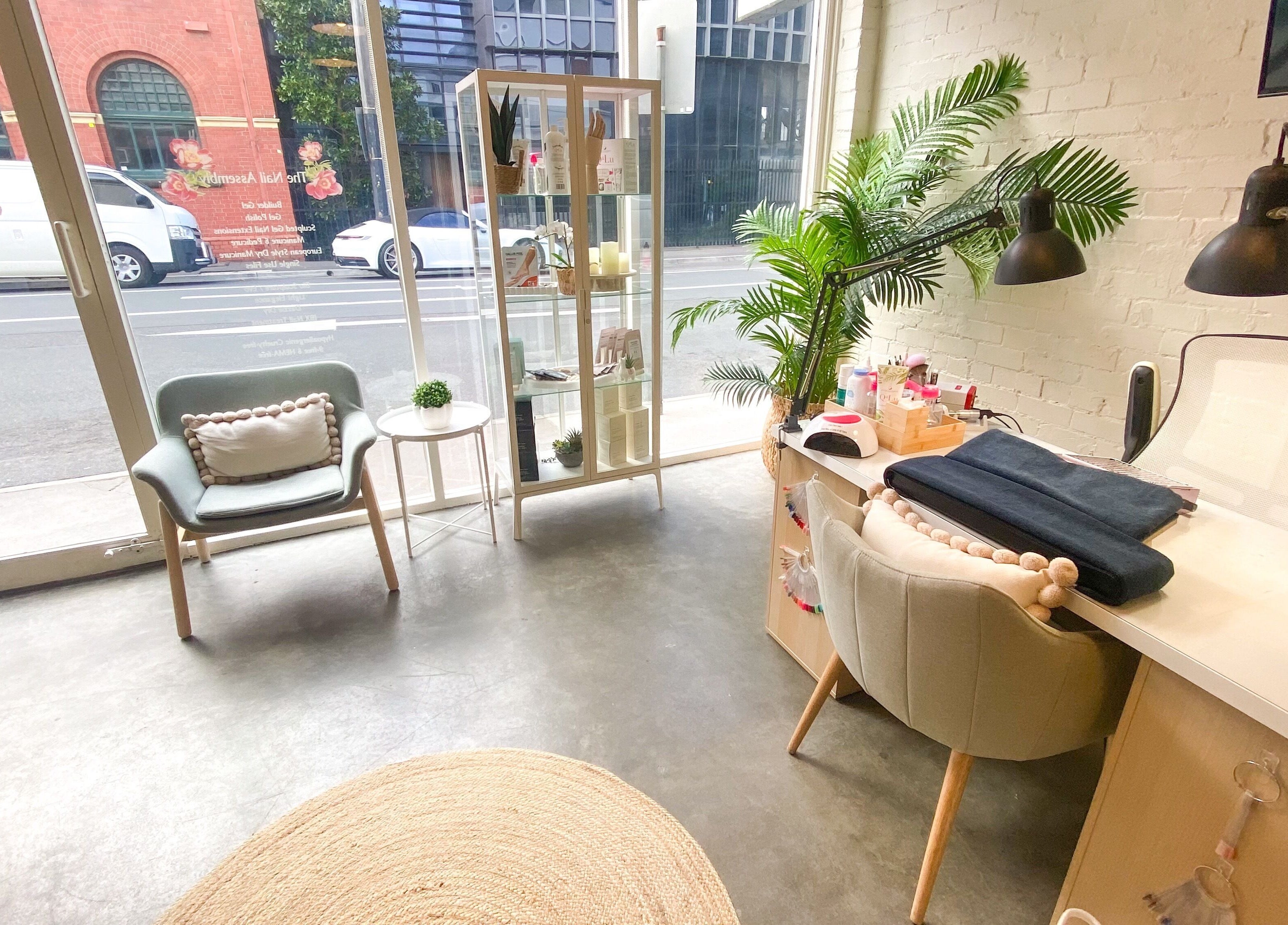 Inviting interior of The Nail Assembly in Melbourne, Victoria, AU with stylish seating and plants.