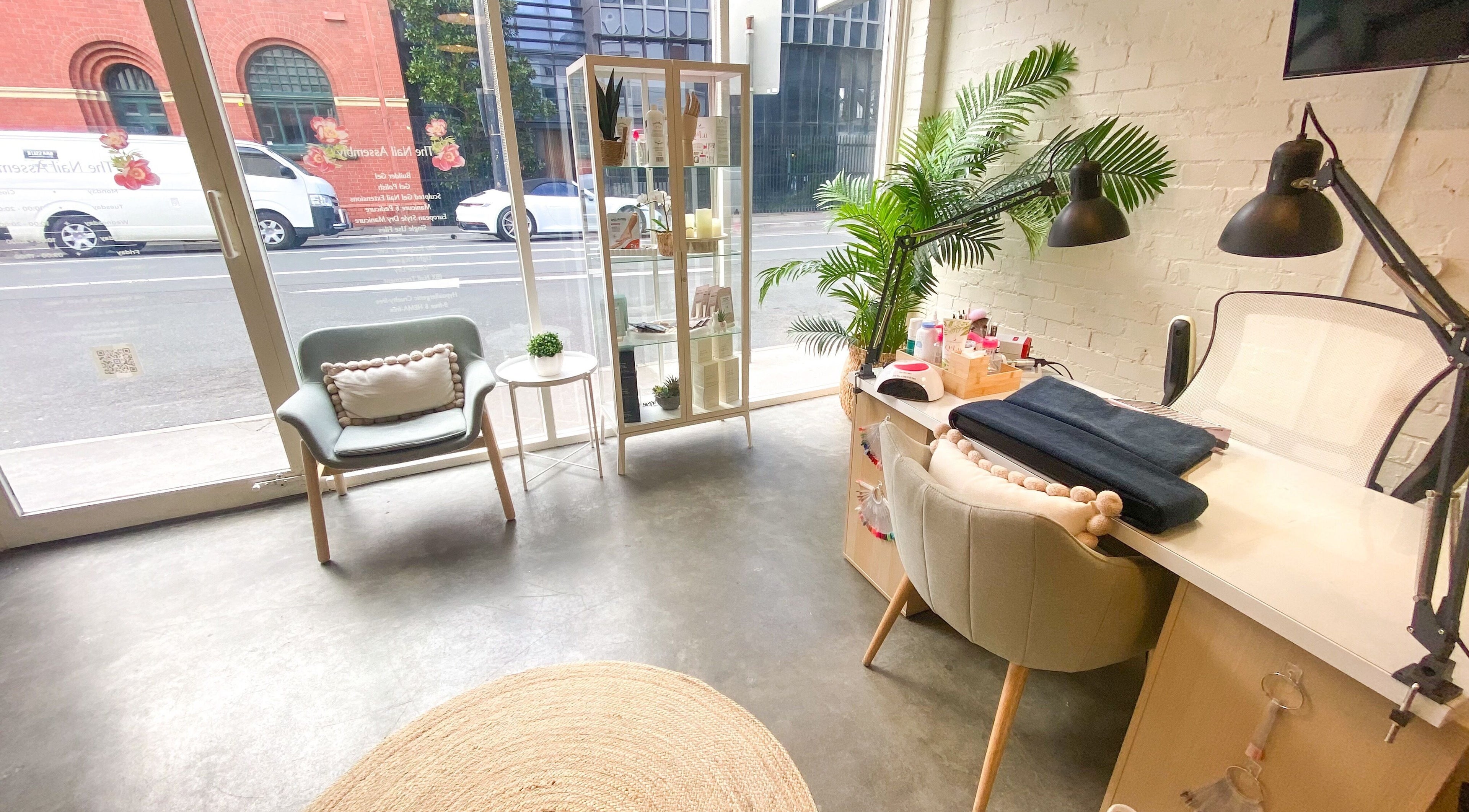 Inviting interior of The Nail Assembly in Melbourne, Victoria, AU with stylish seating and plants.