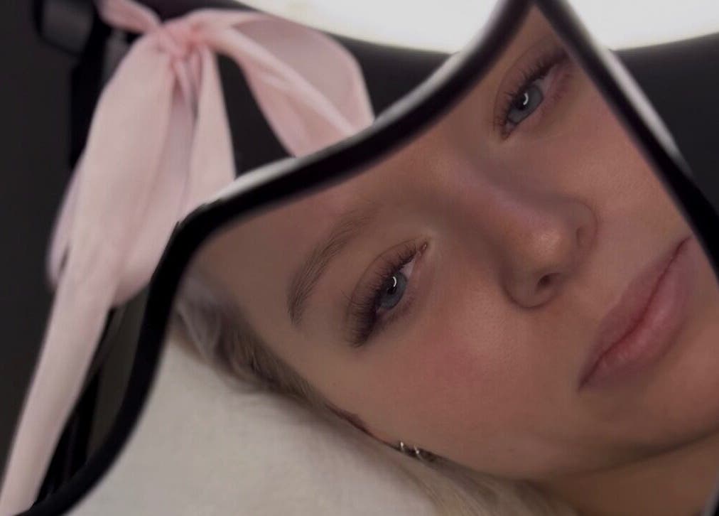 Close-up of a woman's relaxed face reflected in a mirror at CM Lash, Christchurch, Canterbury, NZ.