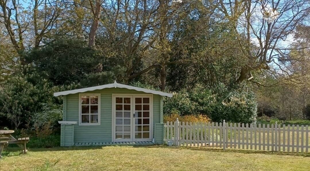 Charming garden cabin at Laura J Lee Therapy, Colchester, England, GB, nestled among trees for serene sessions.