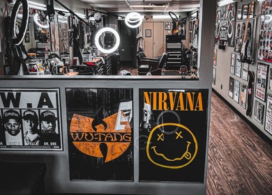 Interior of Barber's Choice Studio, Oakdale, Minnesota, US, featuring retro music posters and barber chairs.
