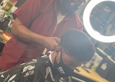 A stylist at Barber’s Choice Studio in Oakdale, Minnesota, US, provides a meticulous haircut under bright lighting.