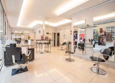 Modern salon interior at Vida hair & beauty The Brewery, Romford, England, GB showcasing sleek black chairs and mirrors.