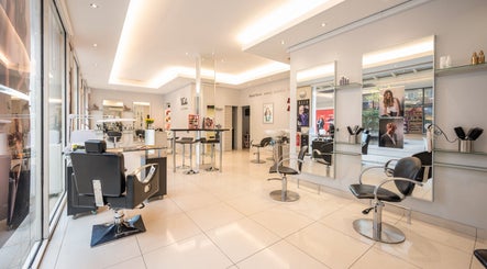 Modern salon interior at Vida hair & beauty The Brewery, Romford, England, GB showcasing sleek black chairs and mirrors.