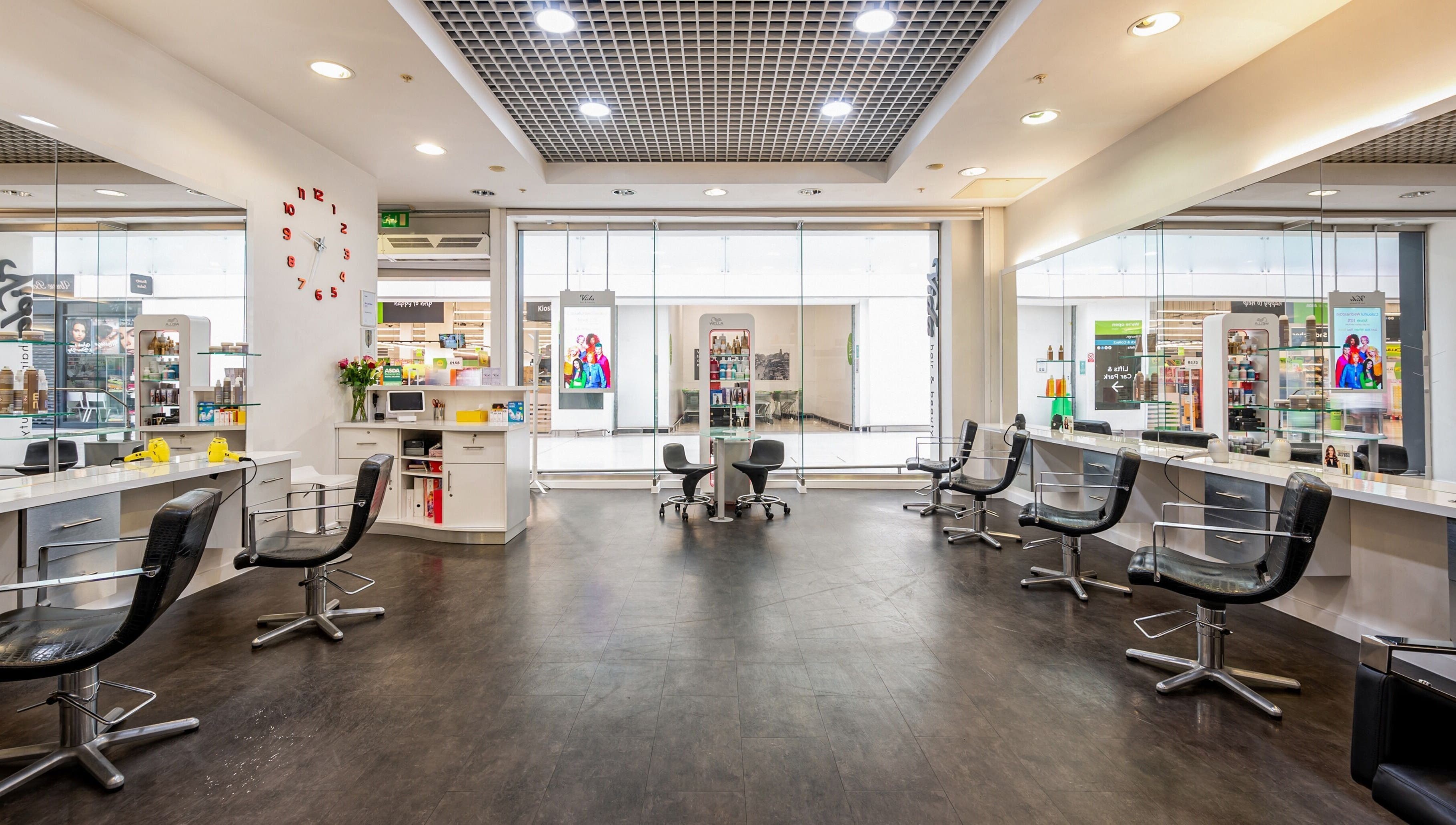 Modern, stylish salon interior at Vida Hair & Beauty The Mercury, Romford, England, GB with sleek black chairs.