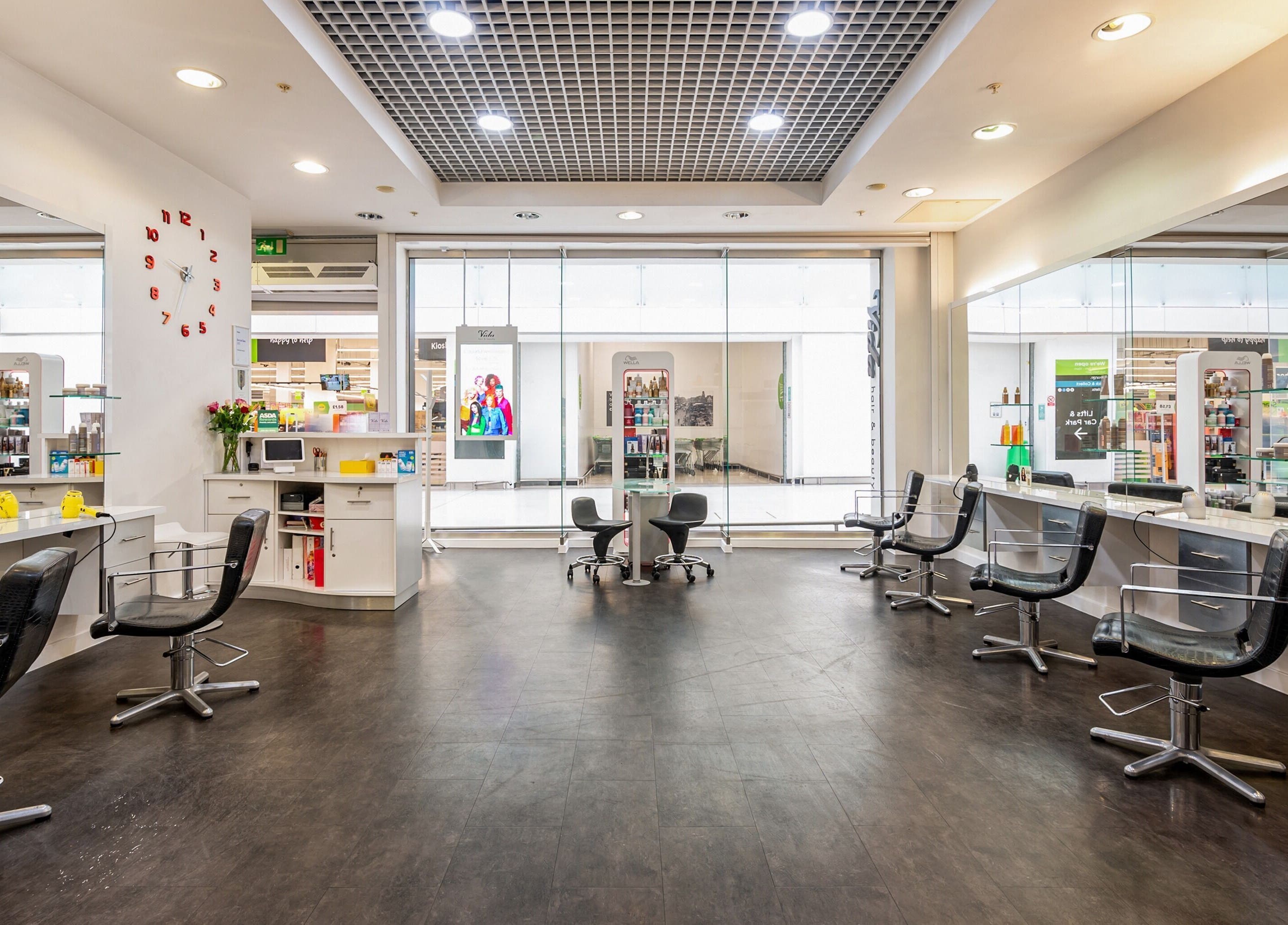 Modern, stylish salon interior at Vida Hair & Beauty The Mercury, Romford, England, GB with sleek black chairs.