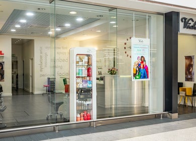 Front view of Vida Hair & Beauty The Mercury, Romford, England with glass facade and inside salon view.