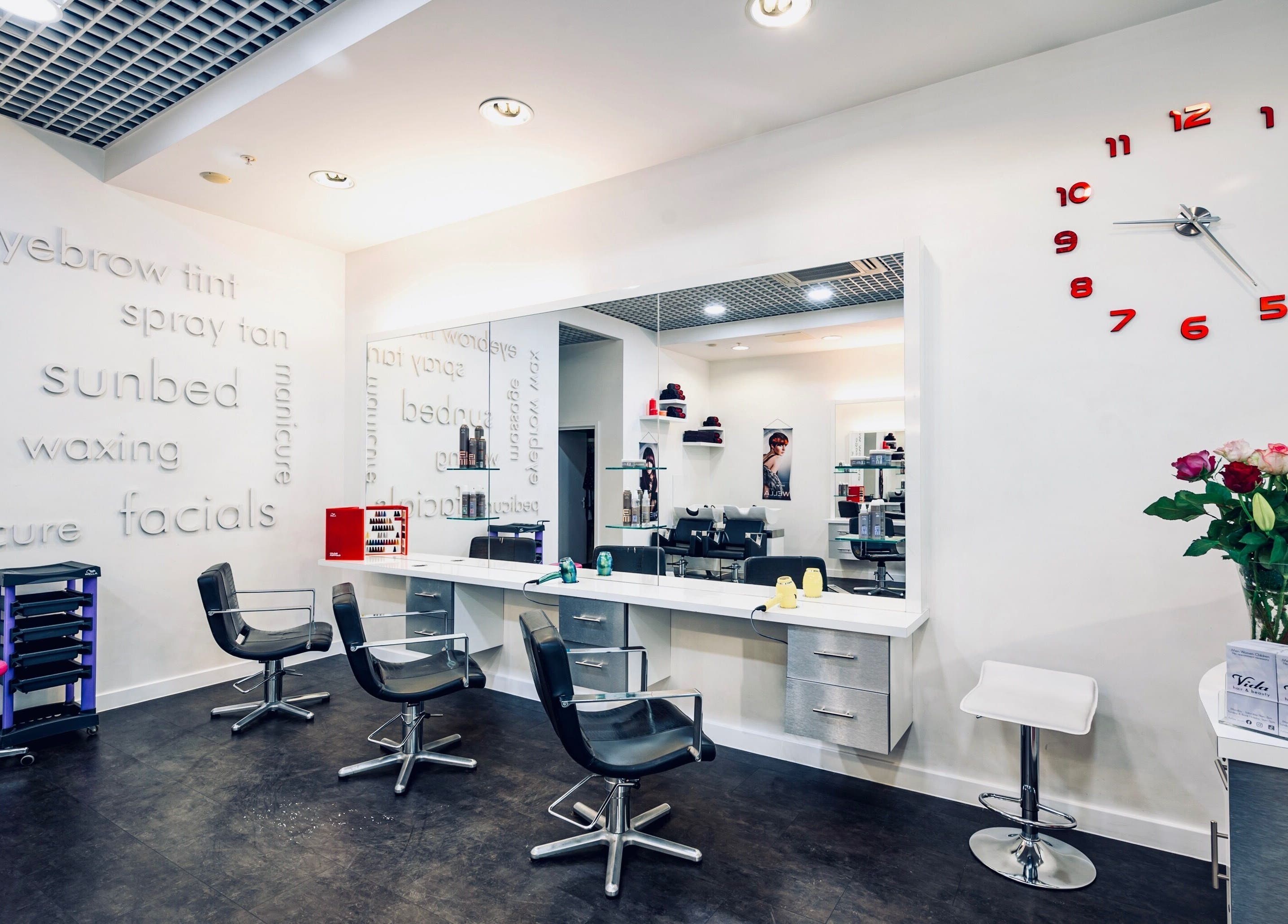 Modern interior of Vida Hair & Beauty The Mercury, Romford, England, GB, showcasing elegant salon chairs and services.