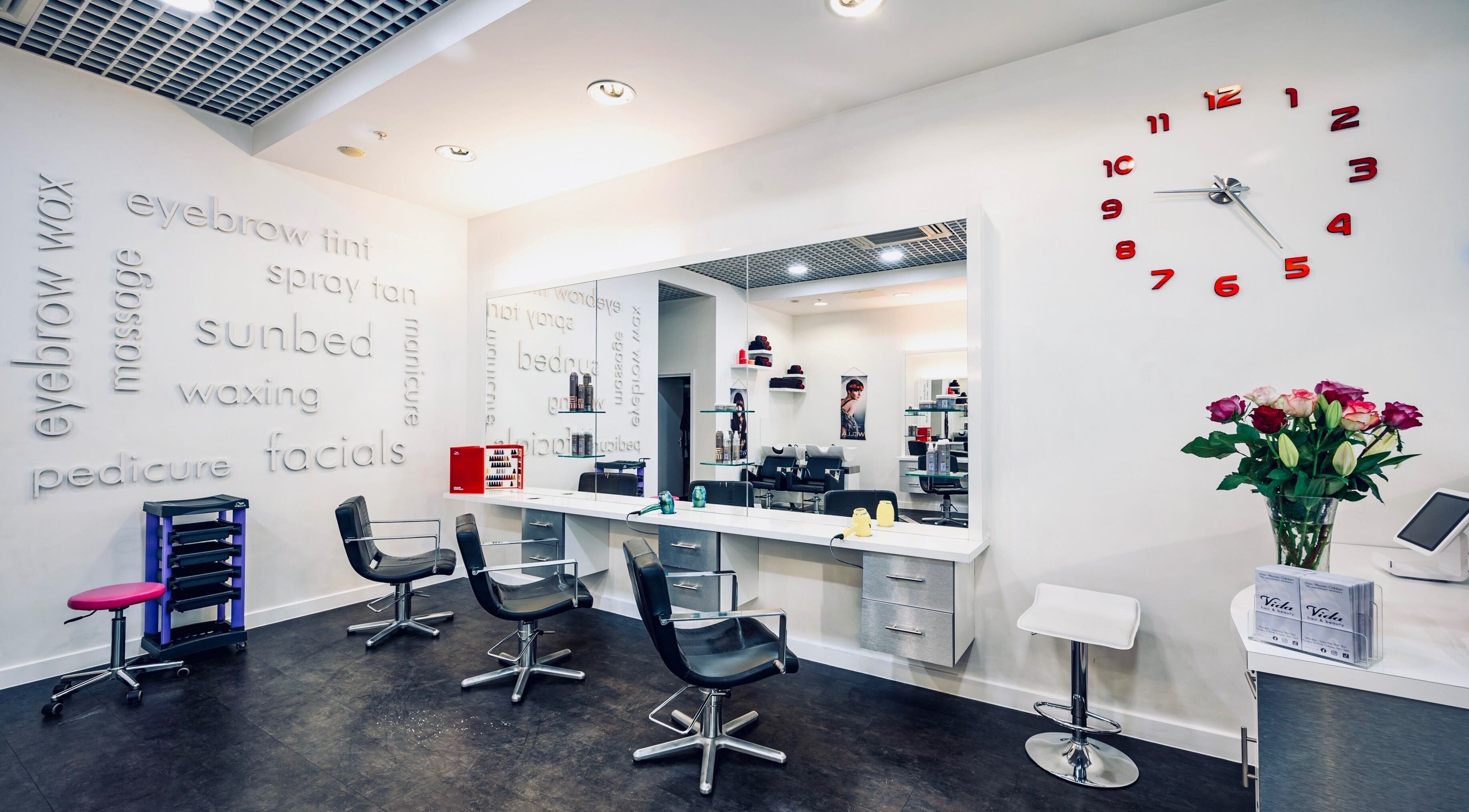 Modern interior of Vida Hair & Beauty The Mercury, Romford, England, GB, showcasing elegant salon chairs and services.