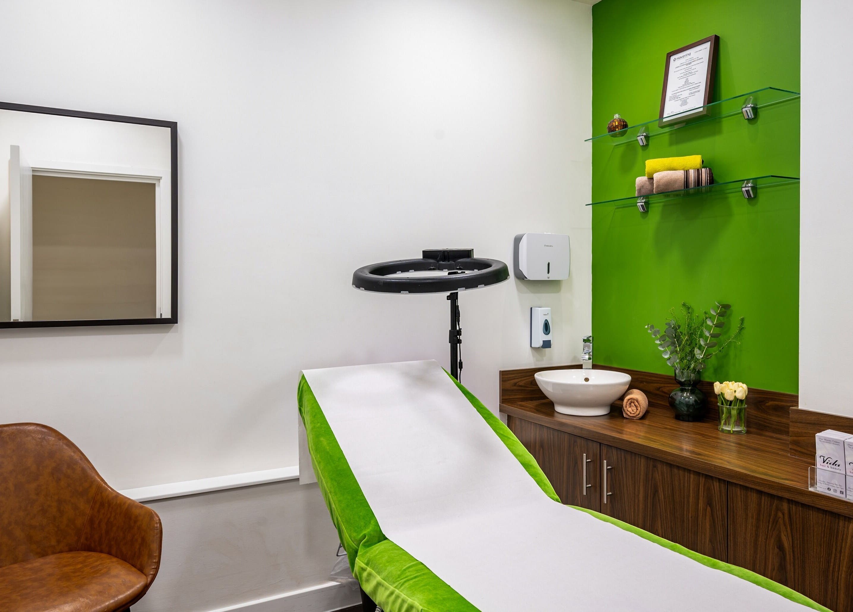 Relaxing treatment room at Vida Hair & Beauty The Mercury, Romford, England, GB with green and white décor.