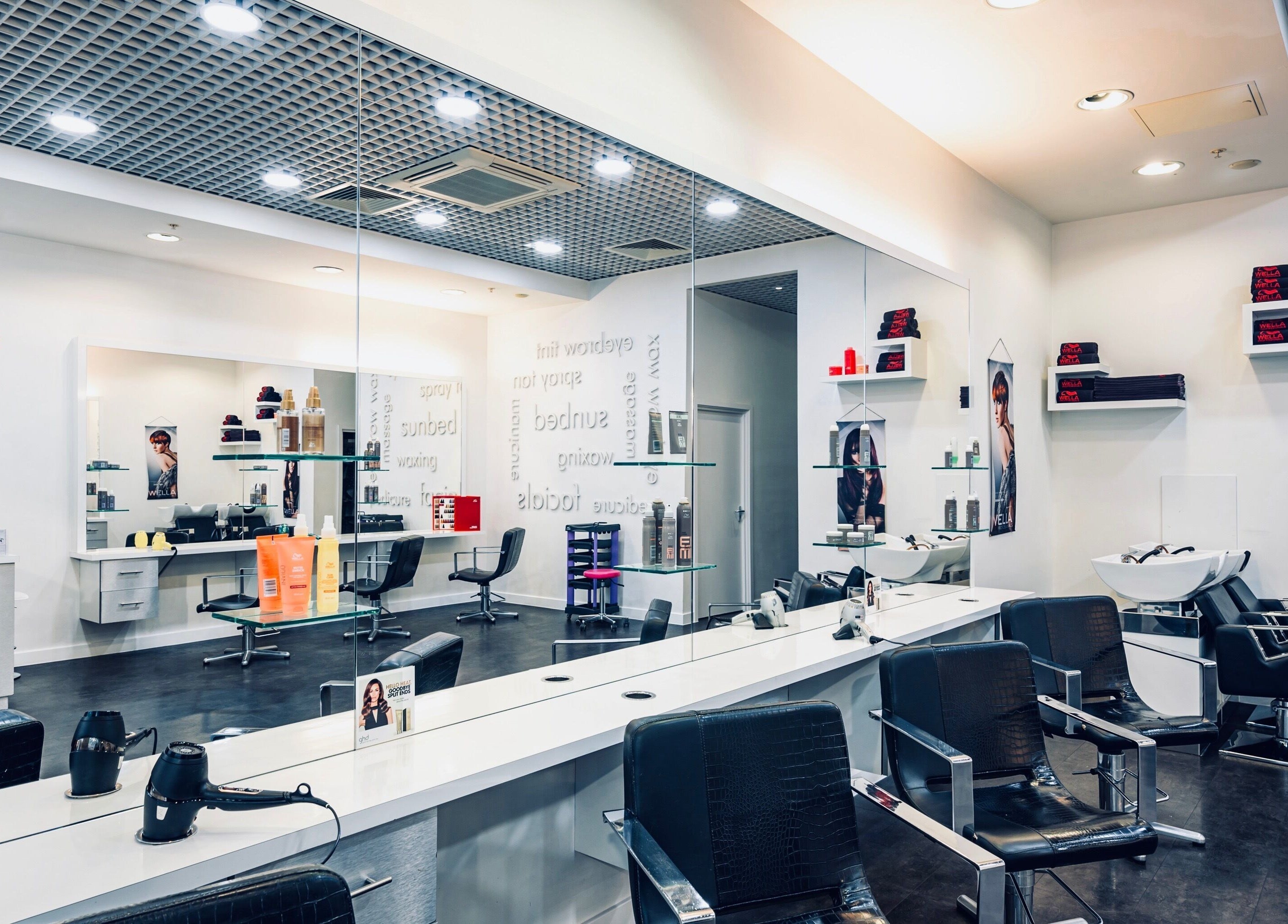 Stylish salon interior at Vida Hair & Beauty The Mercury, Romford, England, GB, showcasing modern chairs and styling tools.