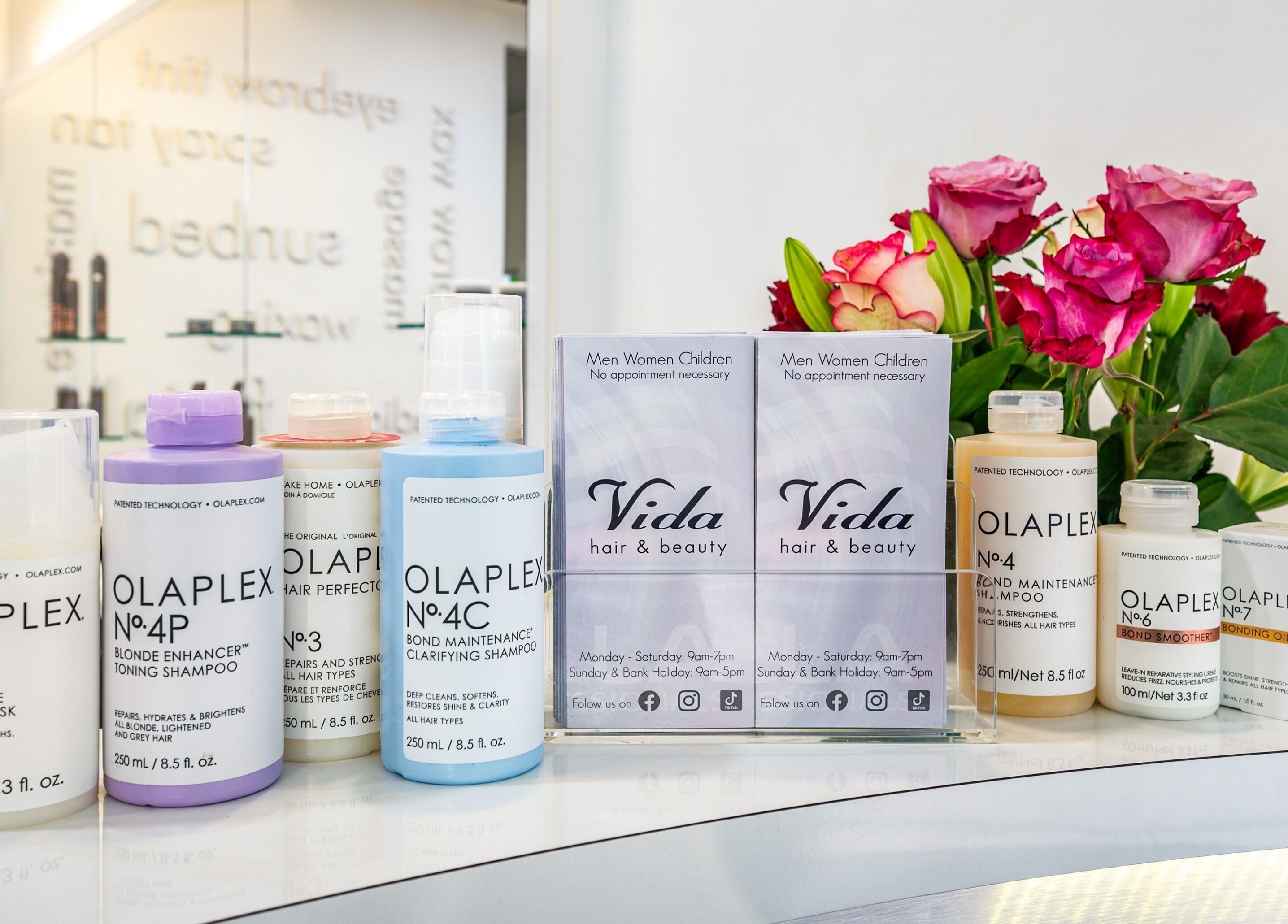 Olaplex products elegantly displayed at Vida Hair & Beauty The Mercury, Romford, England, GB with vibrant flowers.