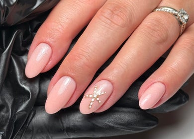 Elegant nail art at Cara Jade Beauty in Wells, England, GB featuring pink polish and star embellishment.