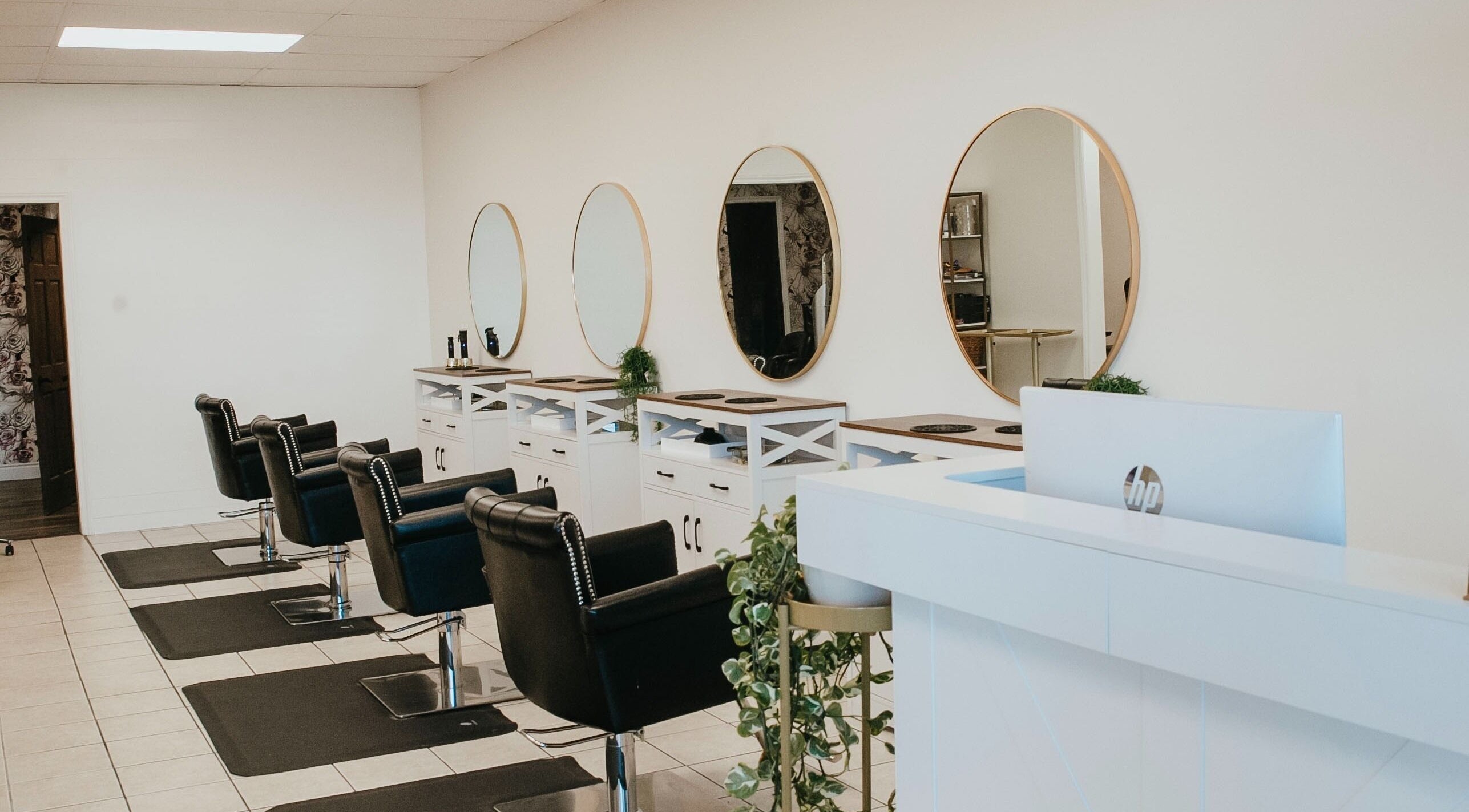 Elegant salon interior at Divinity & Co Hair Studio, Orangeville, Ontario, CA with sleek chairs and mirrors.