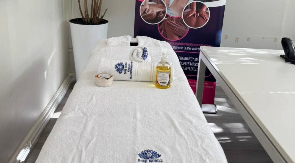 Massage table at Rose Mobile Massage in Cape Town, Western Cape, ZA, with oils and towels displayed.