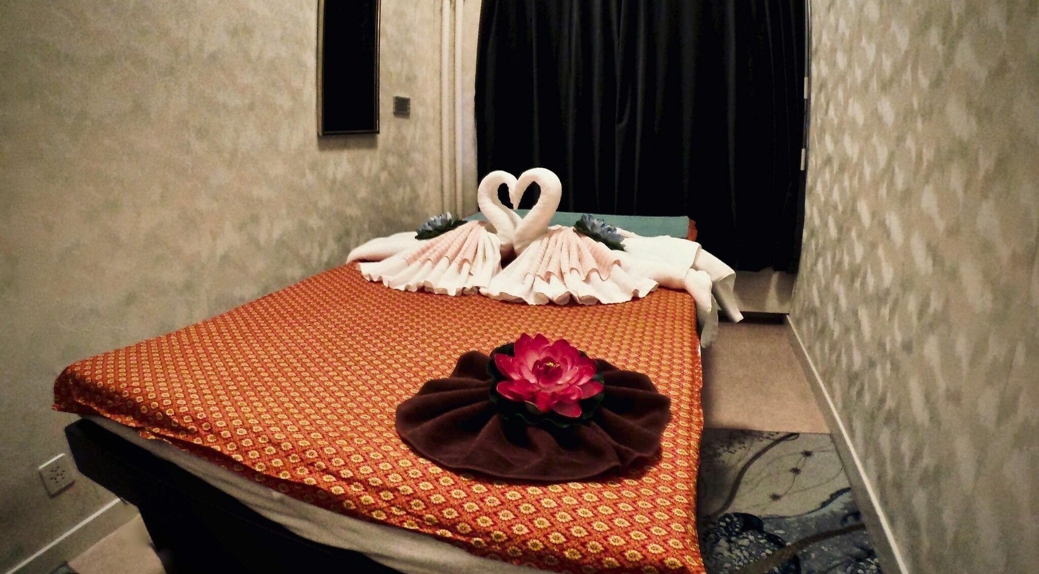 Table de massage élégante avec décoration de cygnes en serviette chez THAI House Massage Geneve, Genève, Genève, CH.