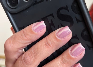 Uñas pintadas de rosa sosteniendo un teléfono en Missbrows.l, Montmagny, Isla de Francia, FR.