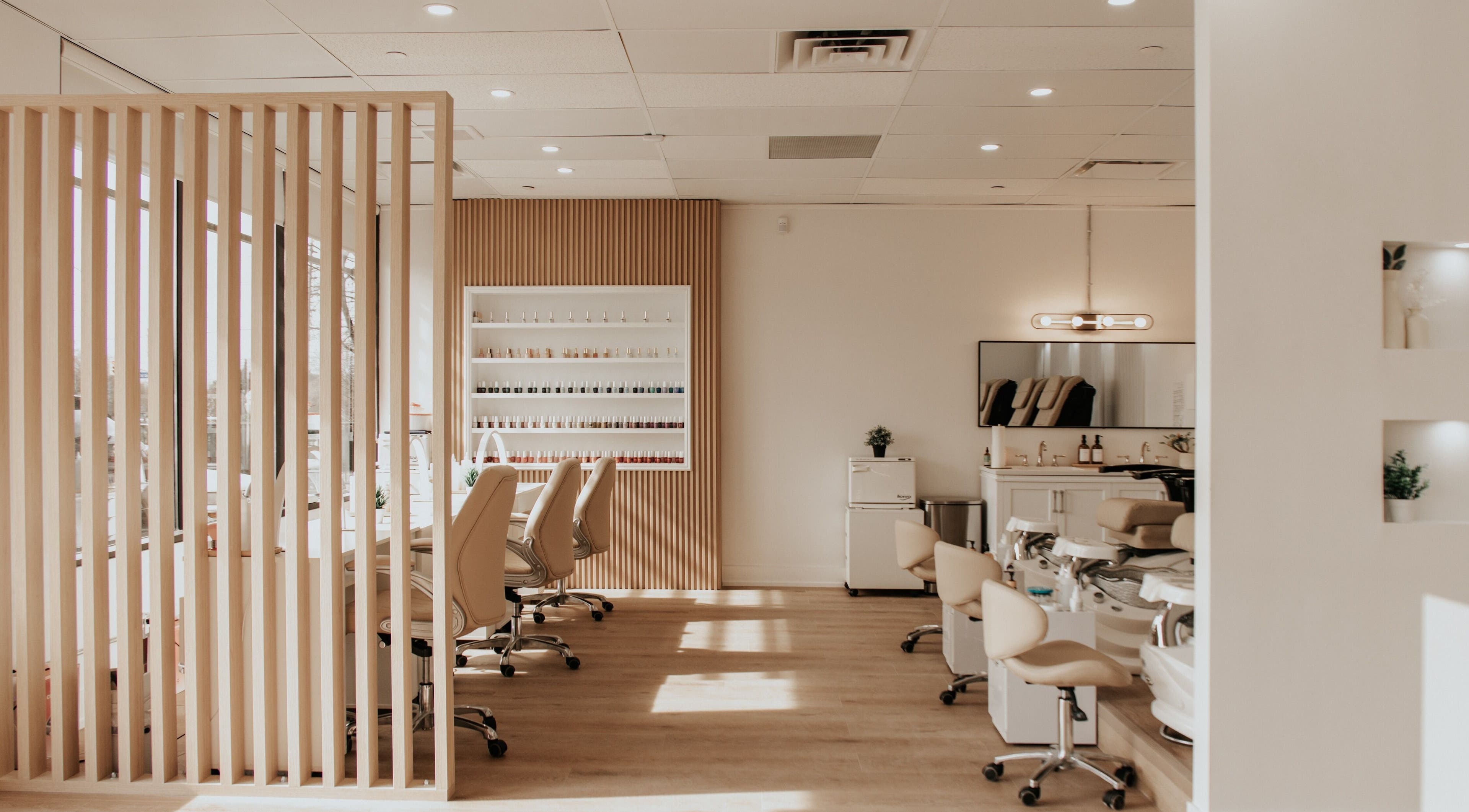 LLBA Beauty Spa's elegant nail salon area in Mississauga, Ontario, CA featuring chic chairs and nail polish display.