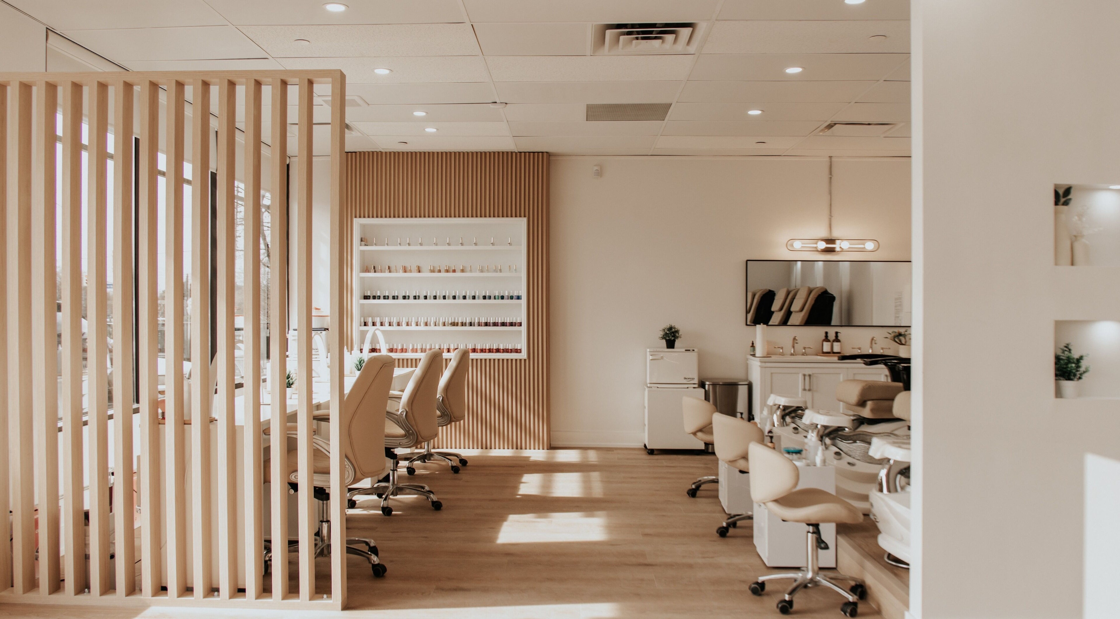 LLBA Beauty Spa's elegant nail salon area in Mississauga, Ontario, CA featuring chic chairs and nail polish display.
