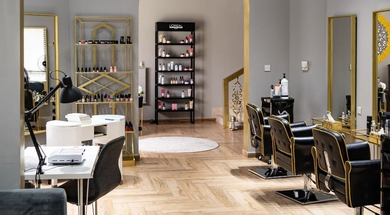 Elegant interior of Rudz Spa Ladies رودز سبا للسيدات in Al Ain, Abu Dhabi, AE with plush chairs and beauty products.