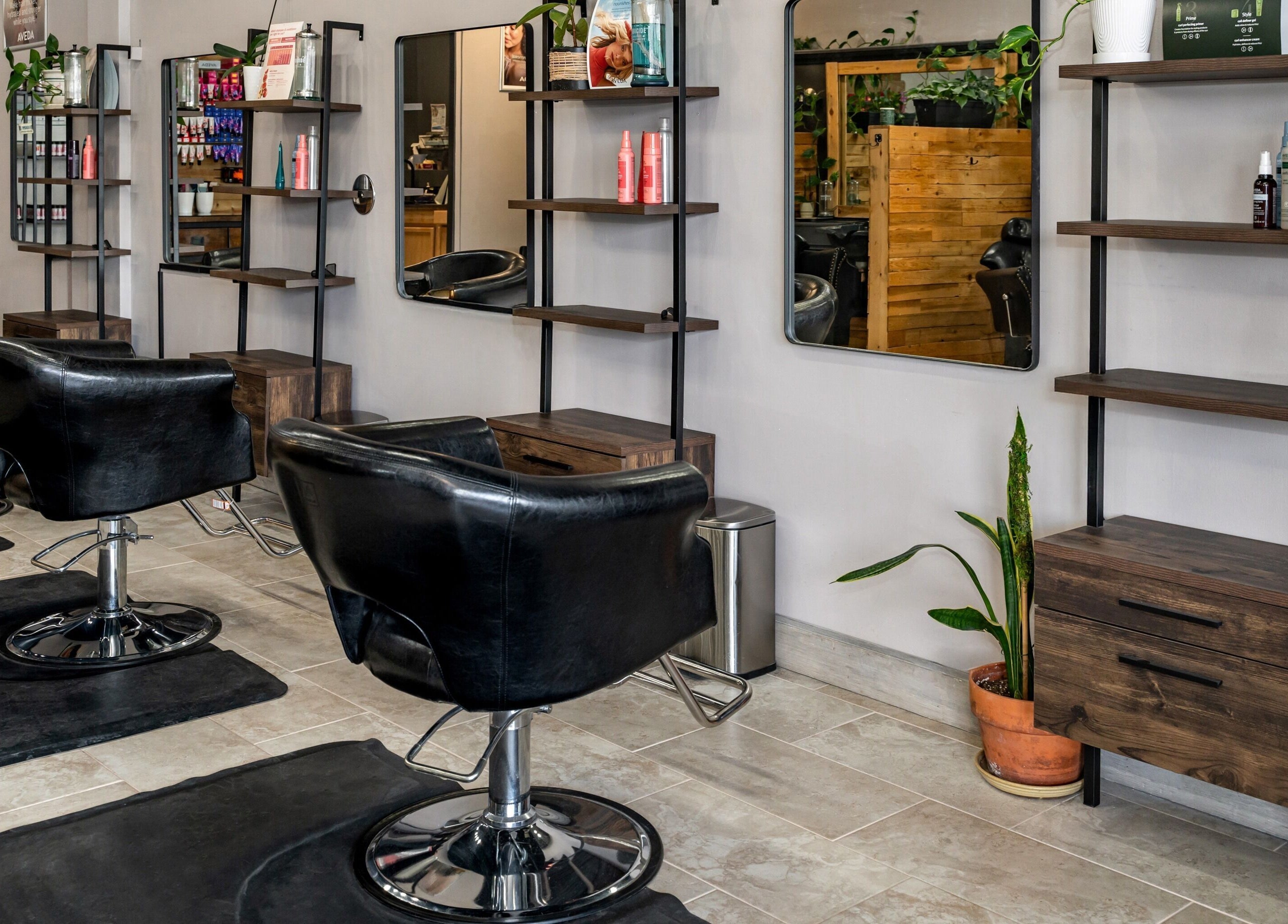 Modern salon interior at Obsessed Salon in Aurora, Colorado, US with sleek black chairs and stylish decor.