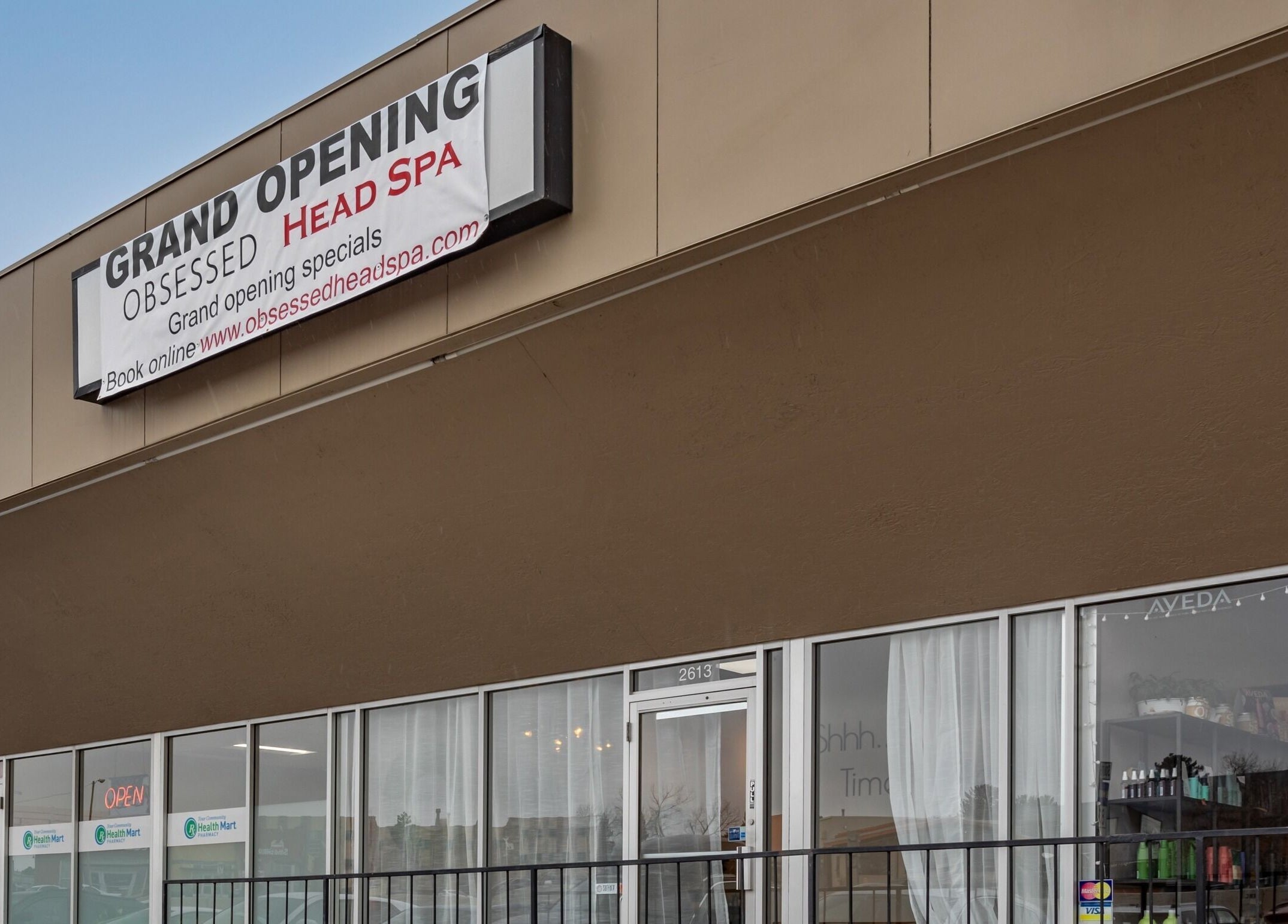 Obsessed Head Spa grand opening with banner in Aurora, Colorado, US storefront view.