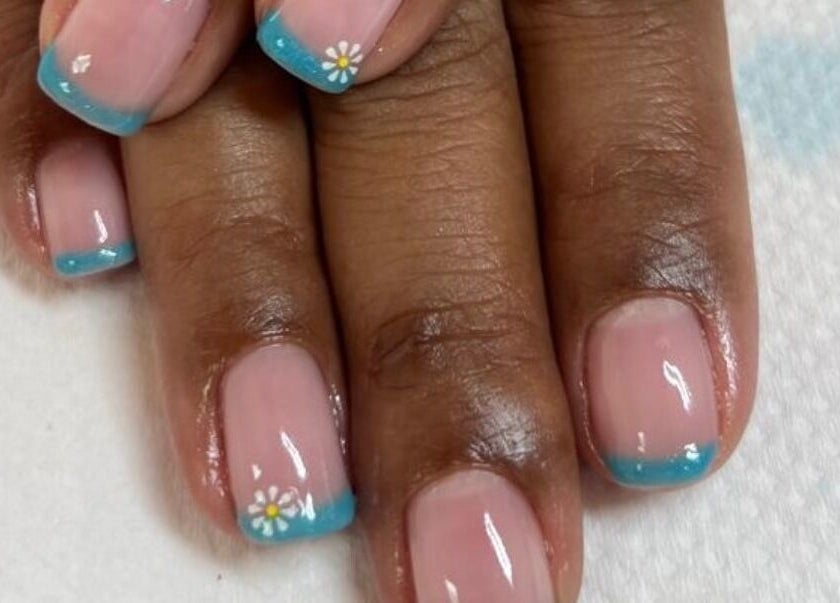 Elegant blue-tipped manicure with floral art at Pamper Me Pink, Cape Town, Western Cape, ZA.