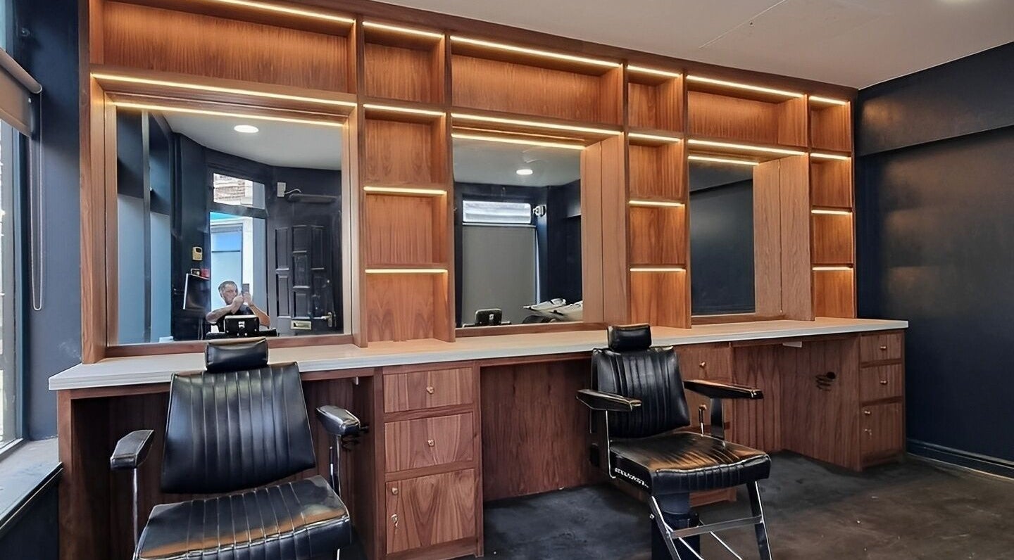 Elegant interior of Citadel Barbershop in Sheffield, England, GB with stylish chairs and wooden mirrors.