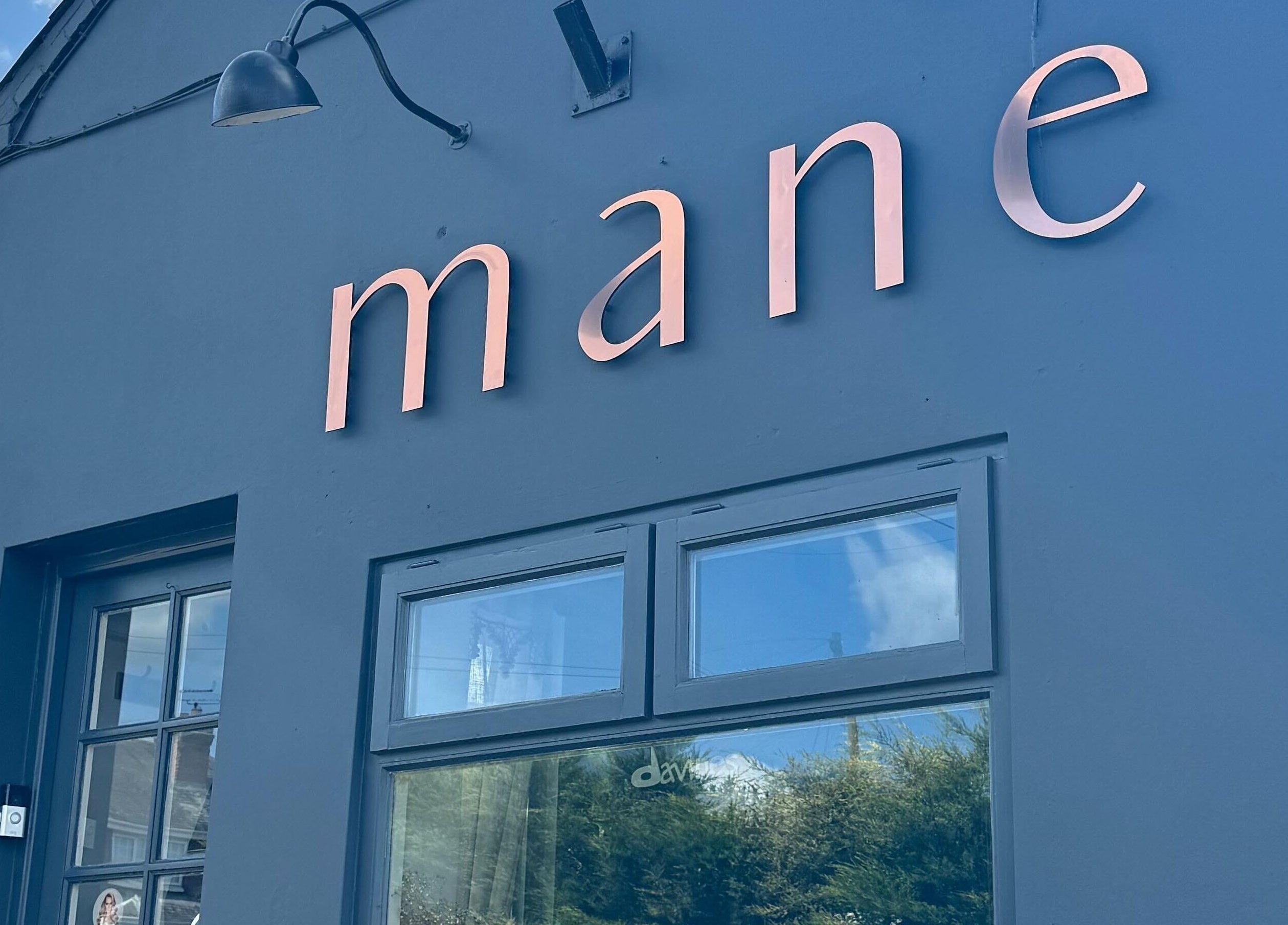 Exterior view of Mane salon, Huncote, England, GB showcasing its modern signage.