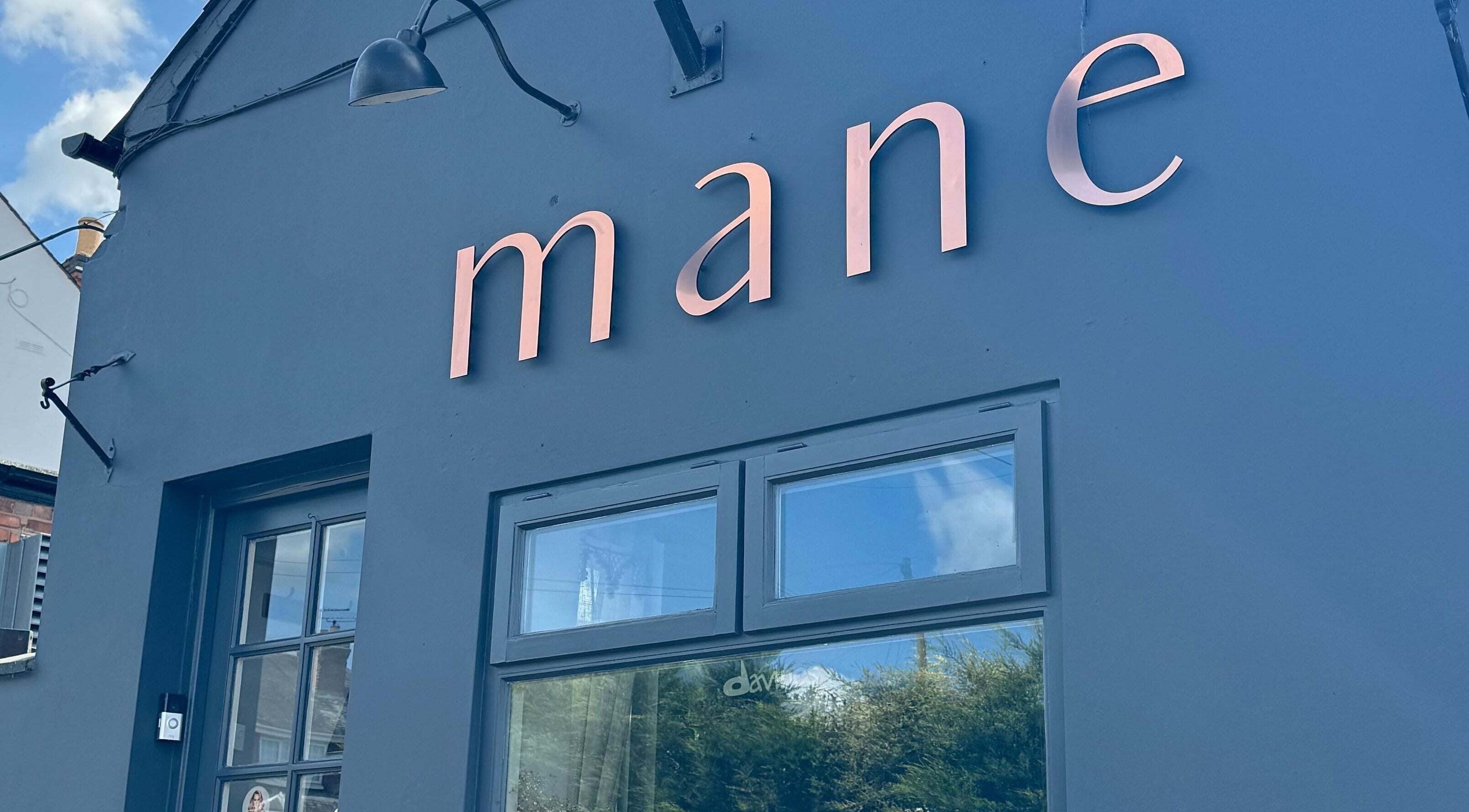 Exterior view of Mane salon, Huncote, England, GB showcasing its modern signage.