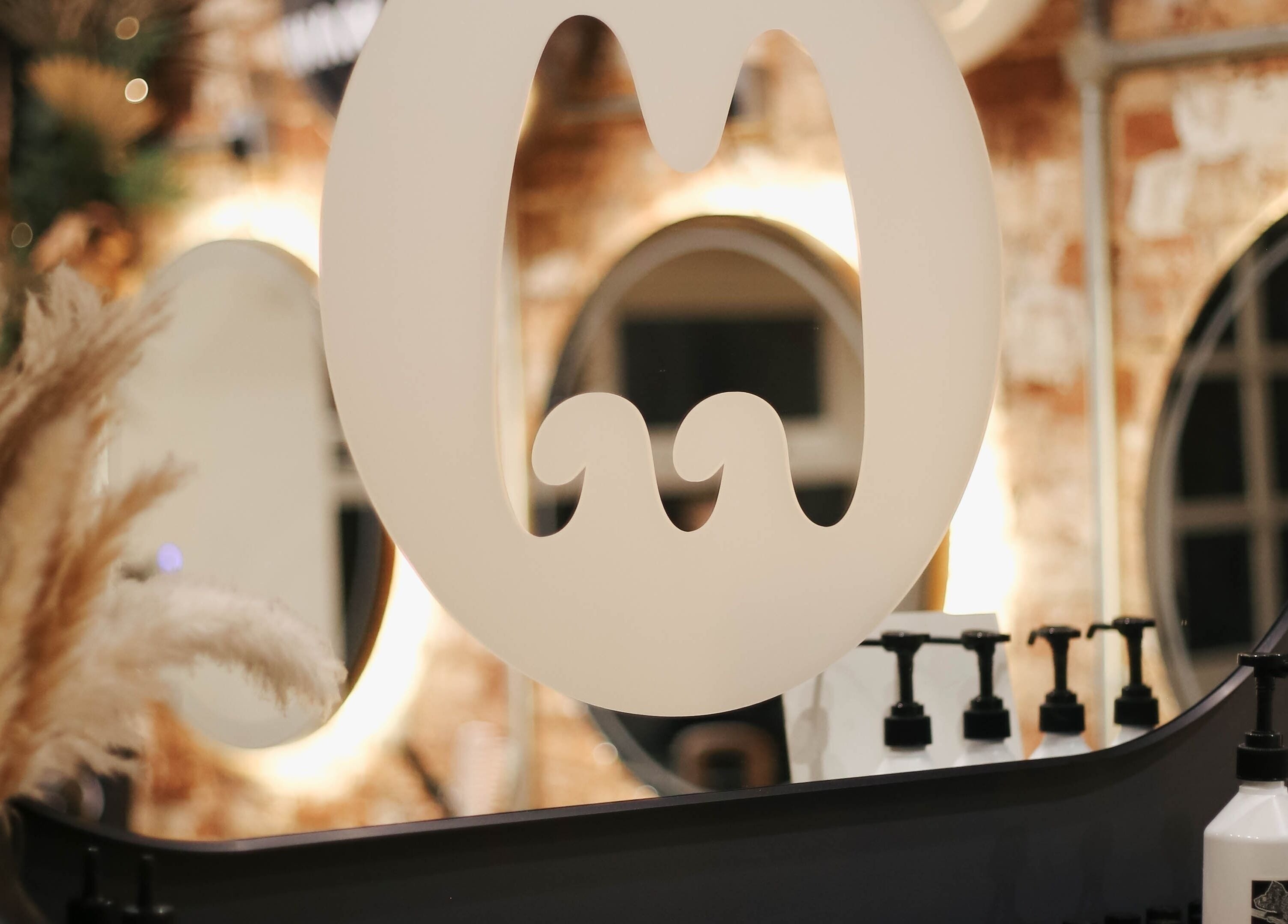 Elegant salon mirror with Mane logo, showcasing stylistic interiors at Huncote, England, GB.