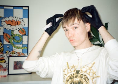 Hair stylist at Studio412, Kingston, Australian Capital Territory, AU, with gloves next to colorful artwork.