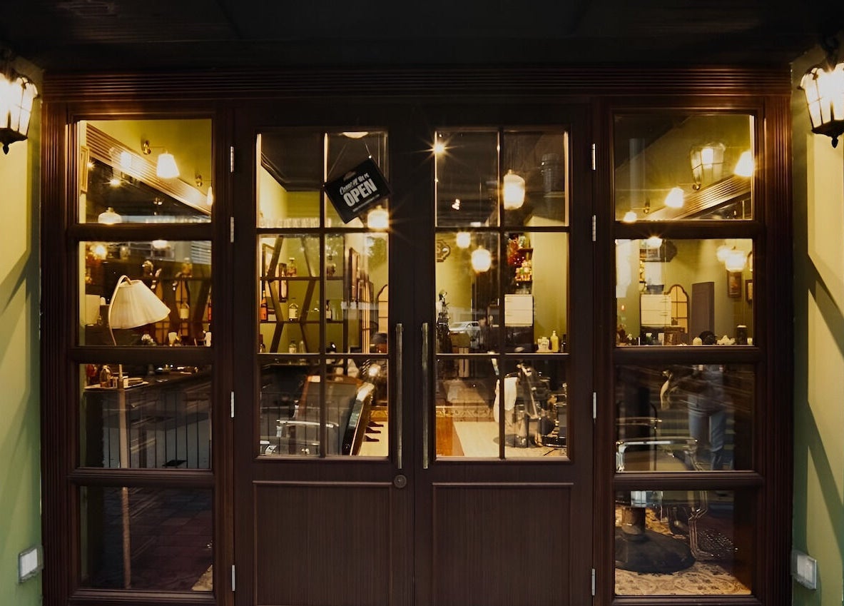 Warmly lit entrance of The Suns Barbershop in 香港島, 香港島, HK, highlighting a classic and inviting ambiance.