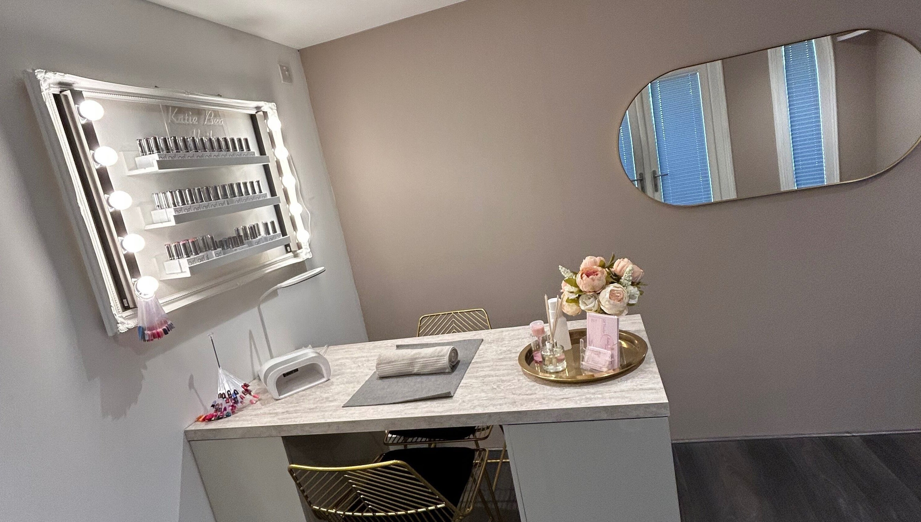 Chic nail station at KatieBea Beauty in Dundee, Scotland, GB. Features a mirror, nail polish display, and flowers.