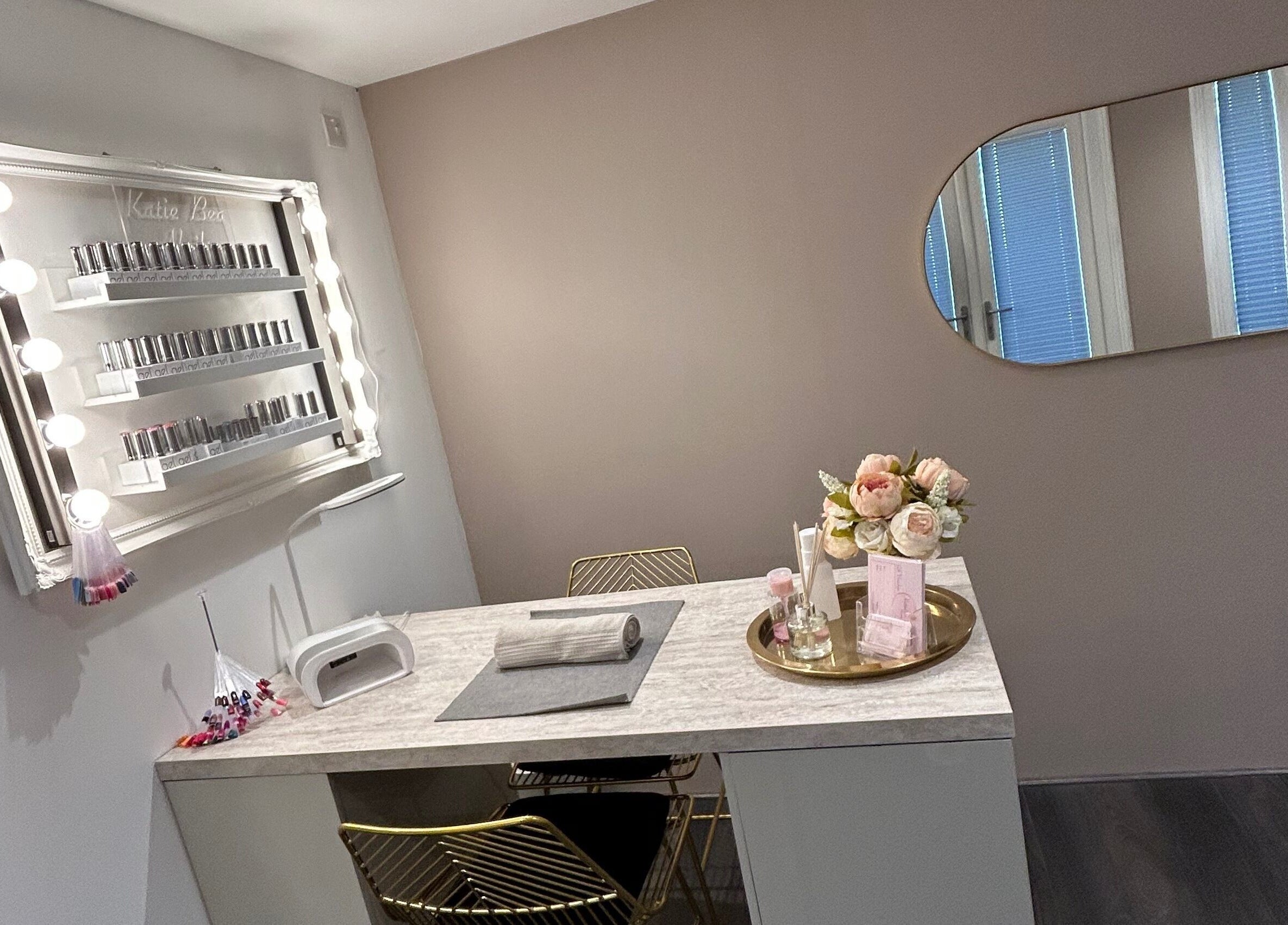 Chic nail station at KatieBea Beauty in Dundee, Scotland, GB. Features a mirror, nail polish display, and flowers.