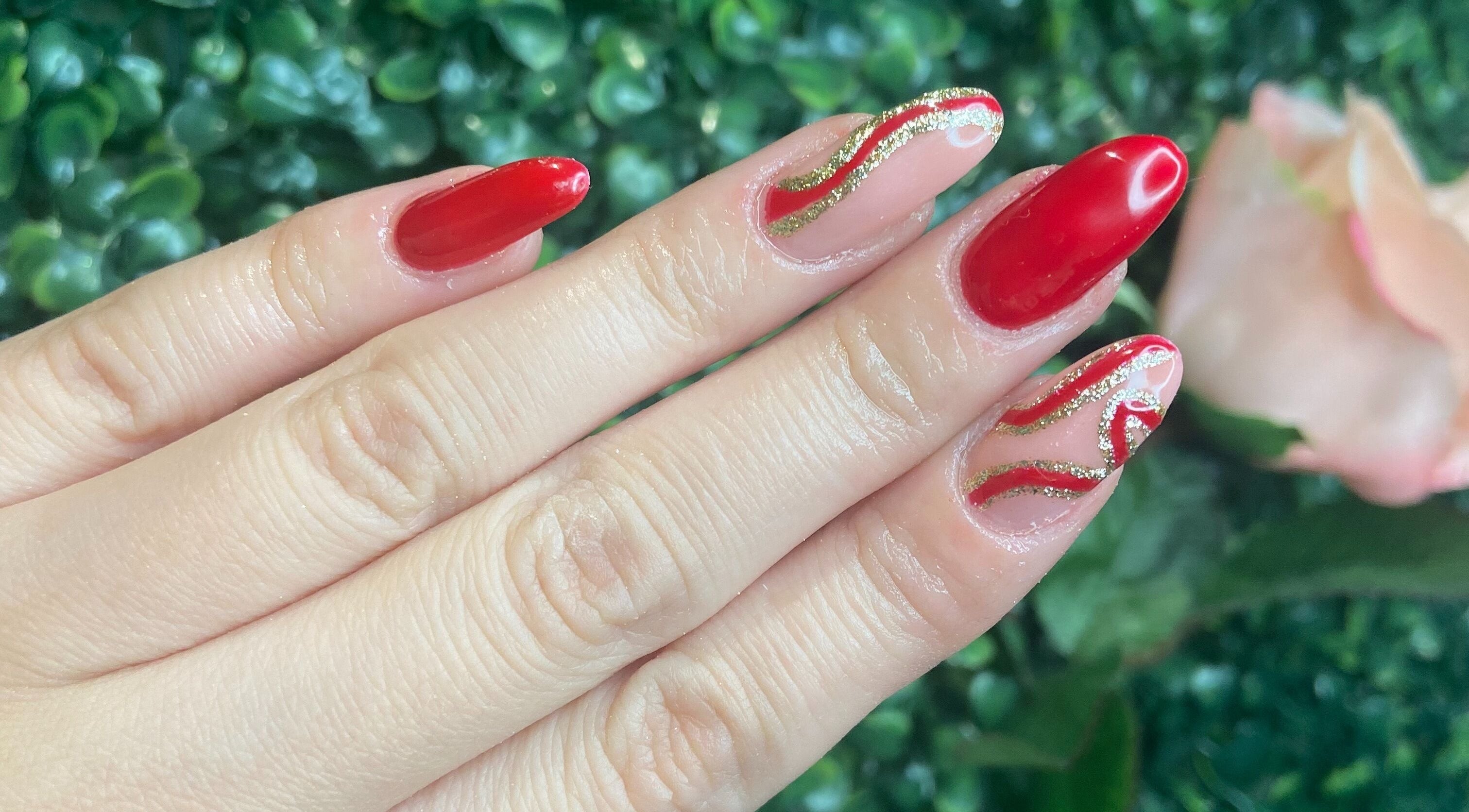 Stylish red nails with gold accents at KatieBea Beauty in Dundee, Scotland, GB.