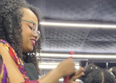 Stylist at Curli Beauti a Division of ALMT Group Limited, Port of Spain, creating elegant curls.