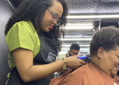 A hairstylist trims a client's hair at Curli Beauti, Port of Spain, Port of Spain Corporation, TT.