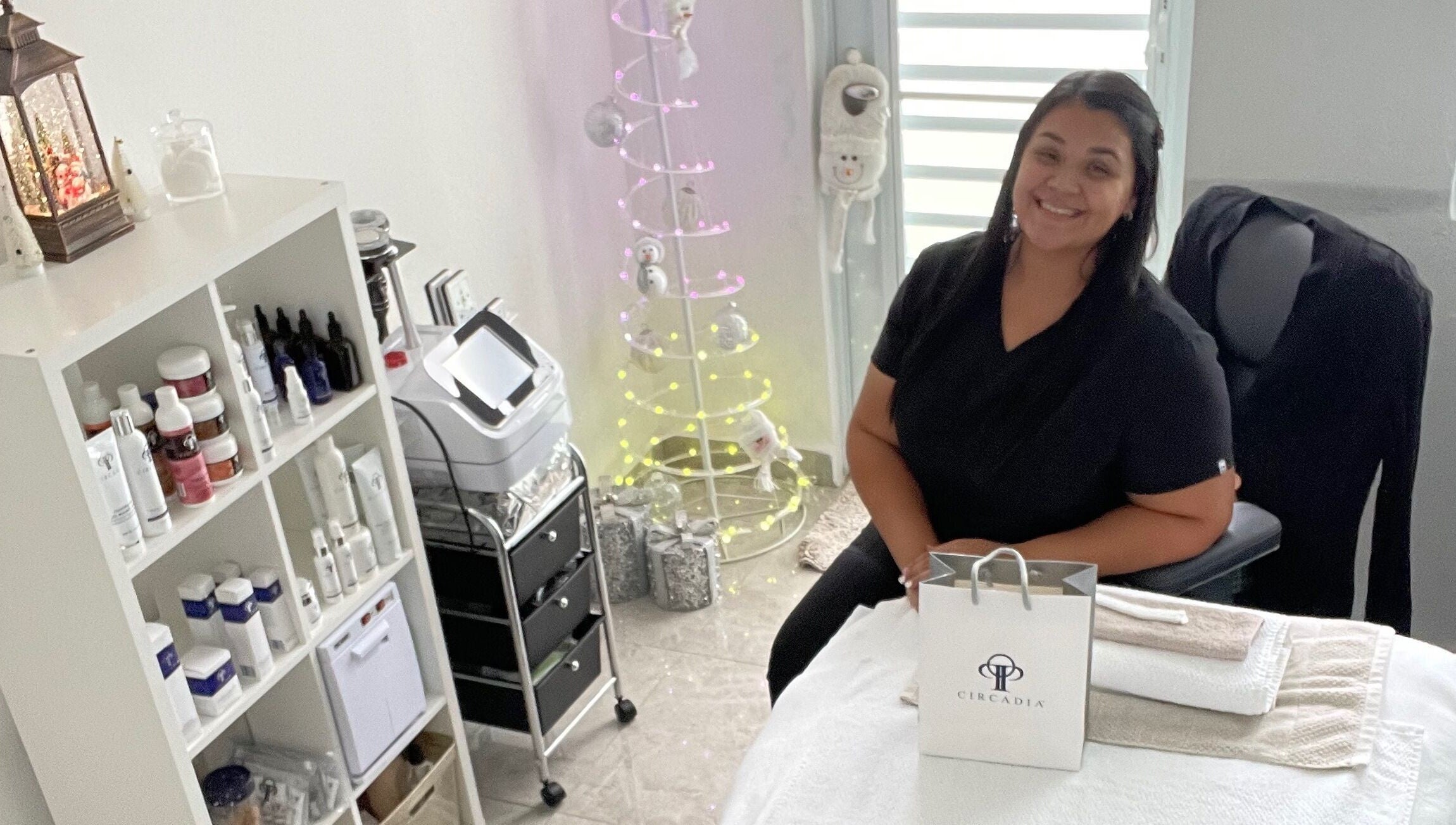 Sala acogedora en Glow Esthetic By Paola, Canovanas, Puerto Rico, US, con terapeuta sonriente y productos de belleza.