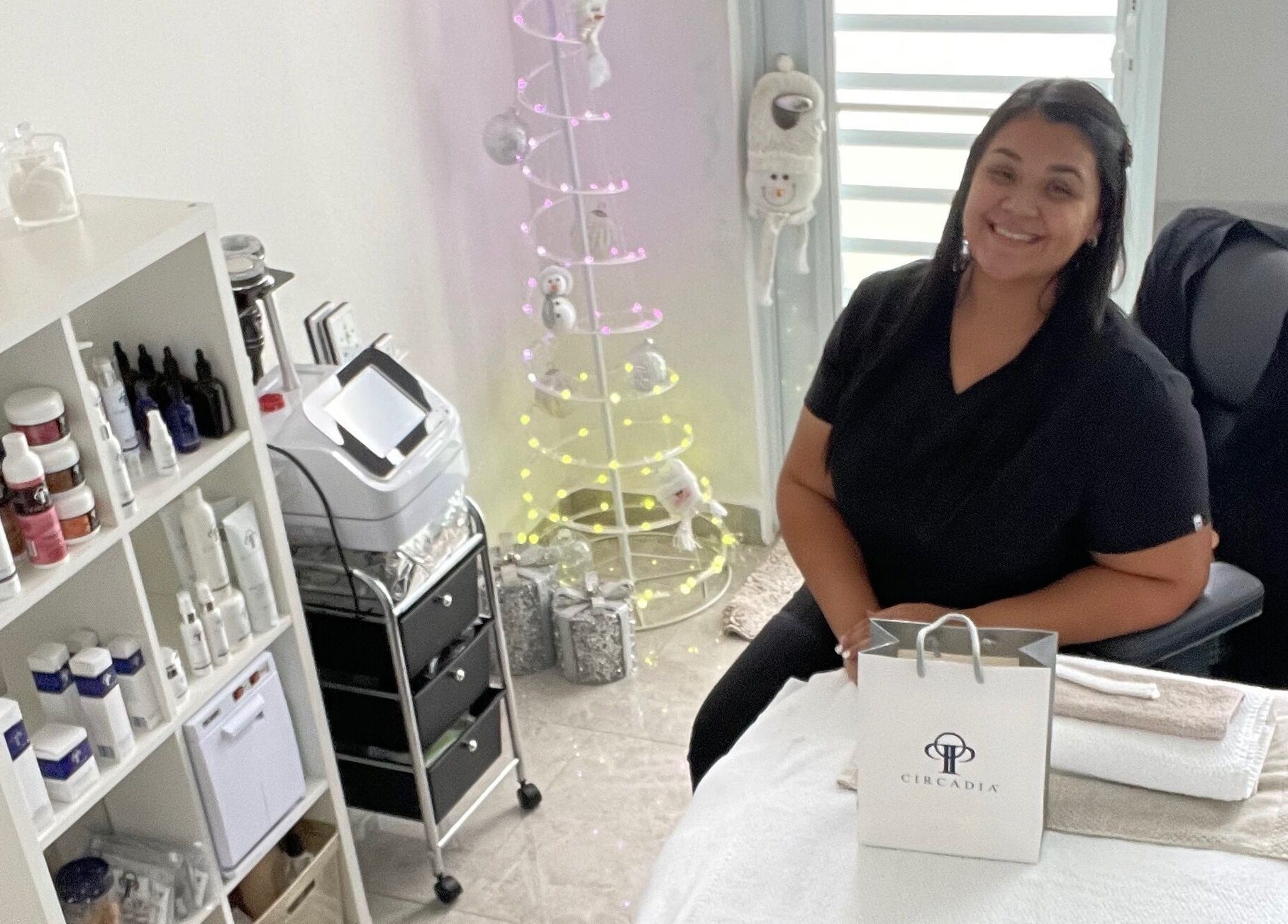 Sala acogedora en Glow Esthetic By Paola, Canovanas, Puerto Rico, US, con terapeuta sonriente y productos de belleza.