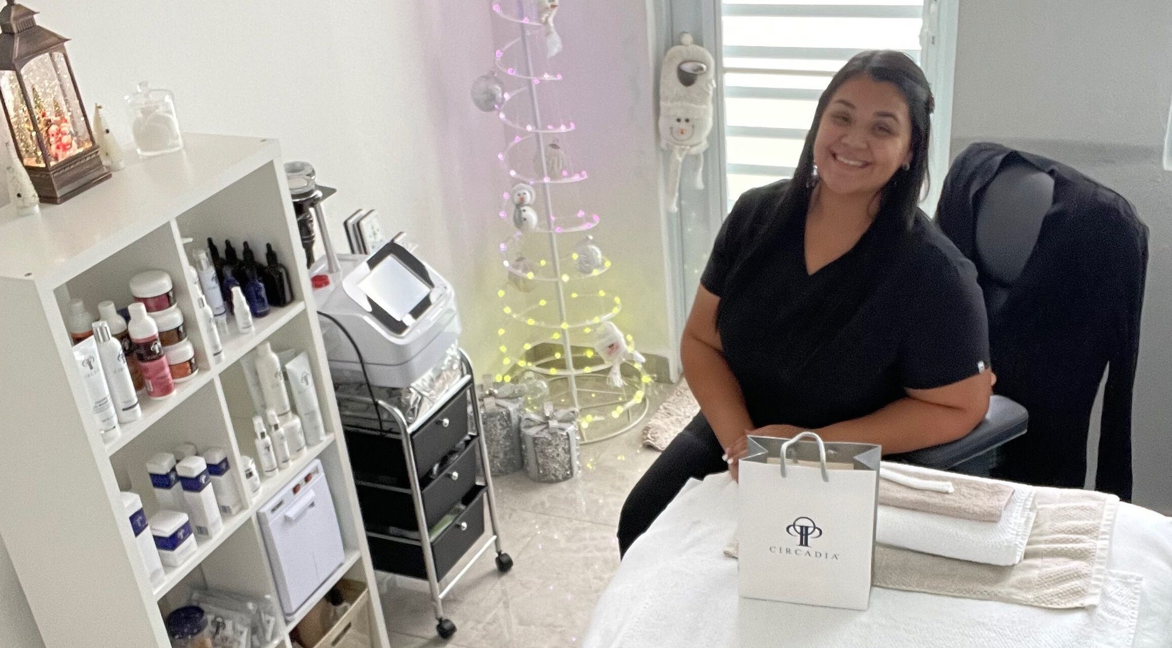 Sala acogedora en Glow Esthetic By Paola, Canovanas, Puerto Rico, US, con terapeuta sonriente y productos de belleza.
