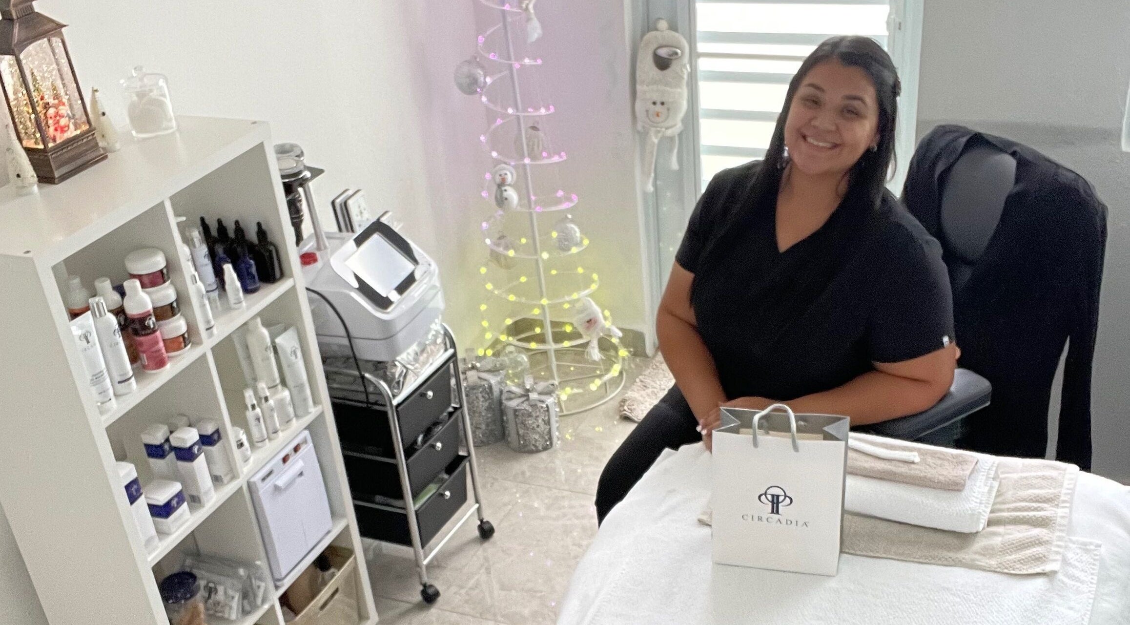 Interior de Glow Esthetic By Paola en Canovanas, Puerto Rico, US, mostrando productos y profesional sonriente.