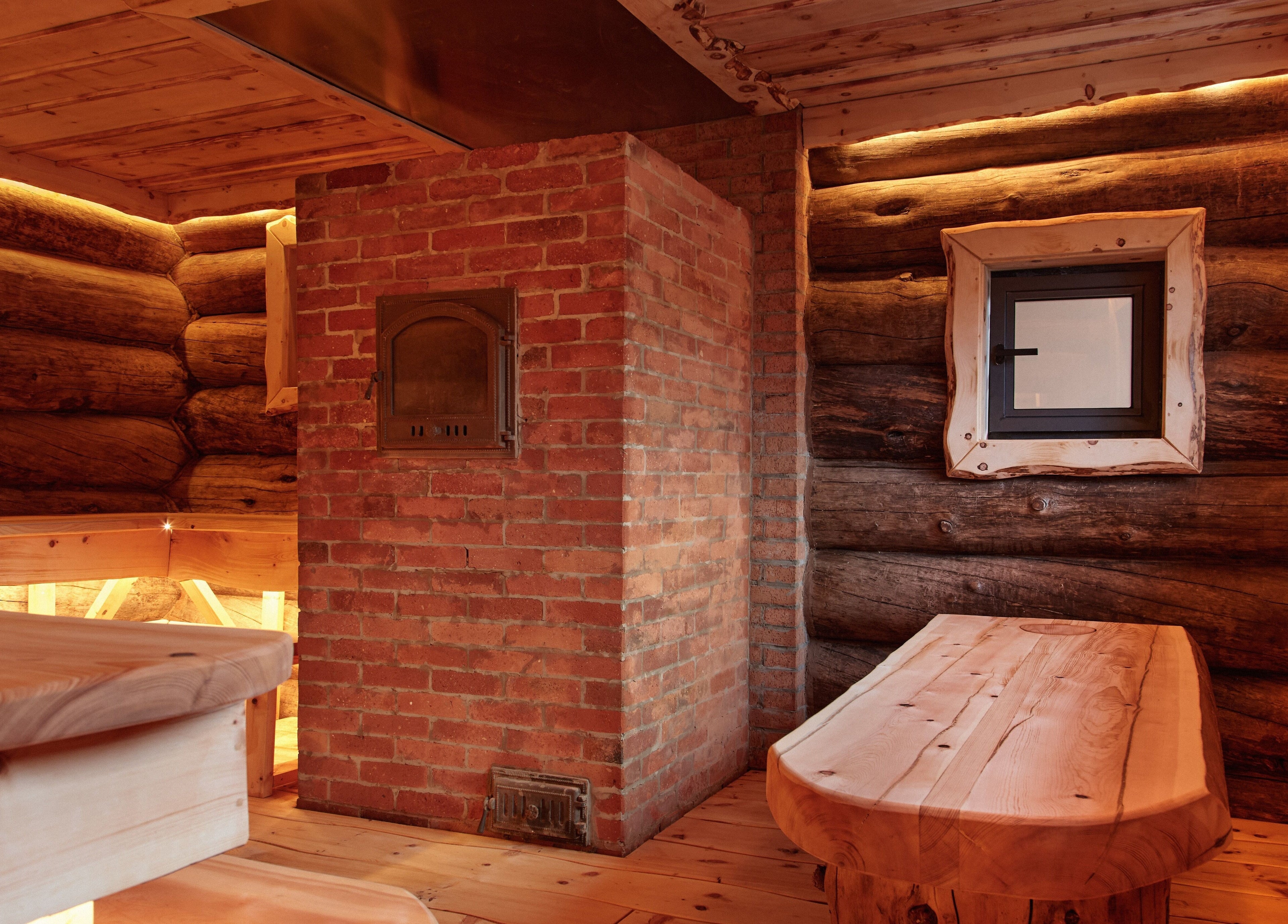Cozy wooden sauna interior at Banya No.1 Tbilisi Private in Kiketi, GE, with brick oven and warm lighting.