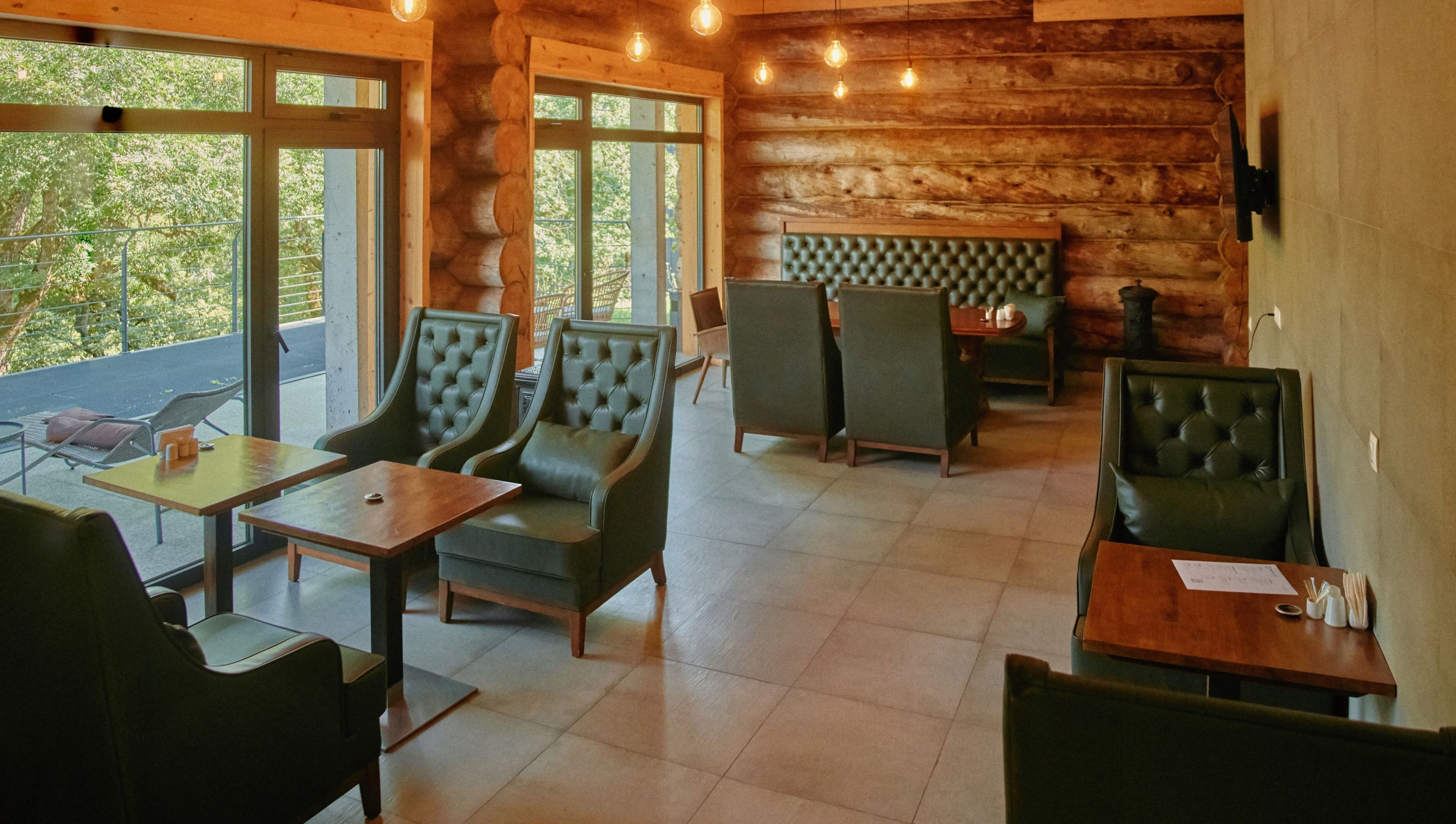 Cozy interior of Banya No.1 - Tbilisi (Public Mixed) in Kiketi, Kvemo Kartli, GE, with leather chairs and log walls.