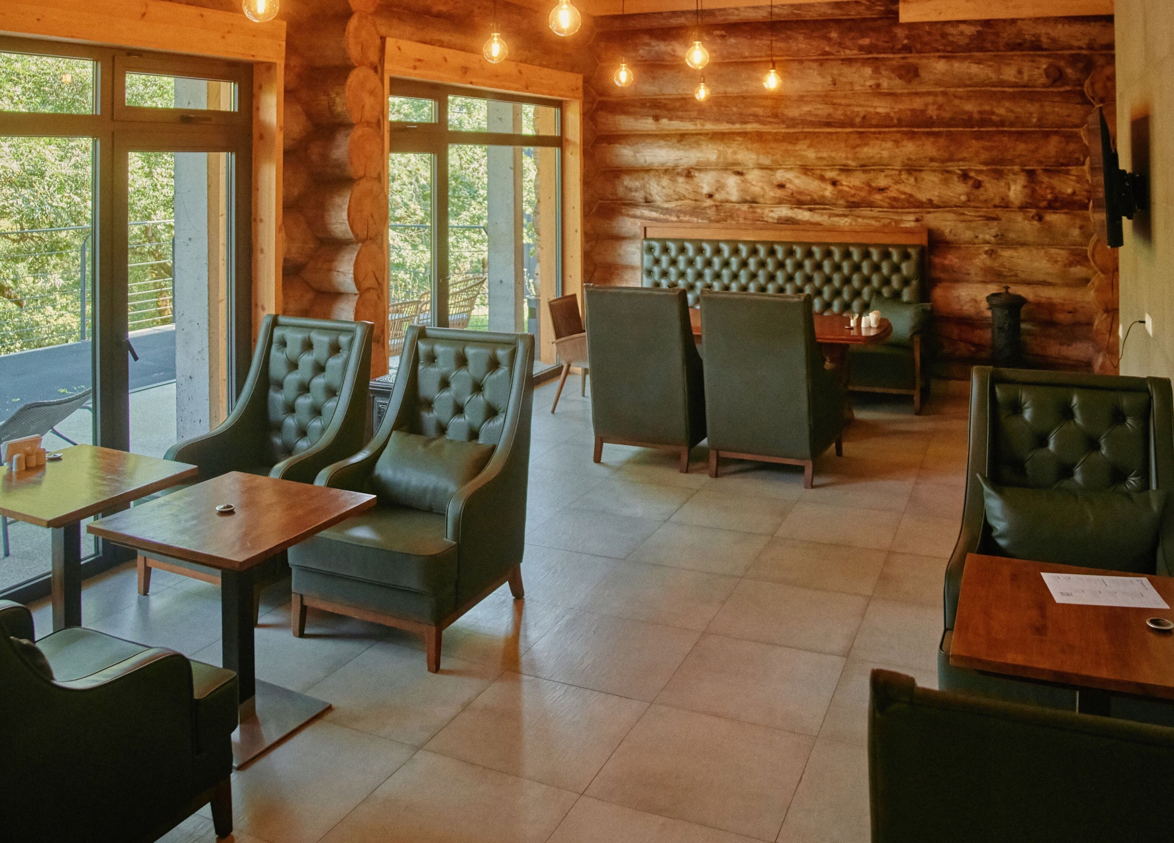 Cozy interior of Banya No.1 - Tbilisi (Public Mixed) in Kiketi, Kvemo Kartli, GE, with leather chairs and log walls.